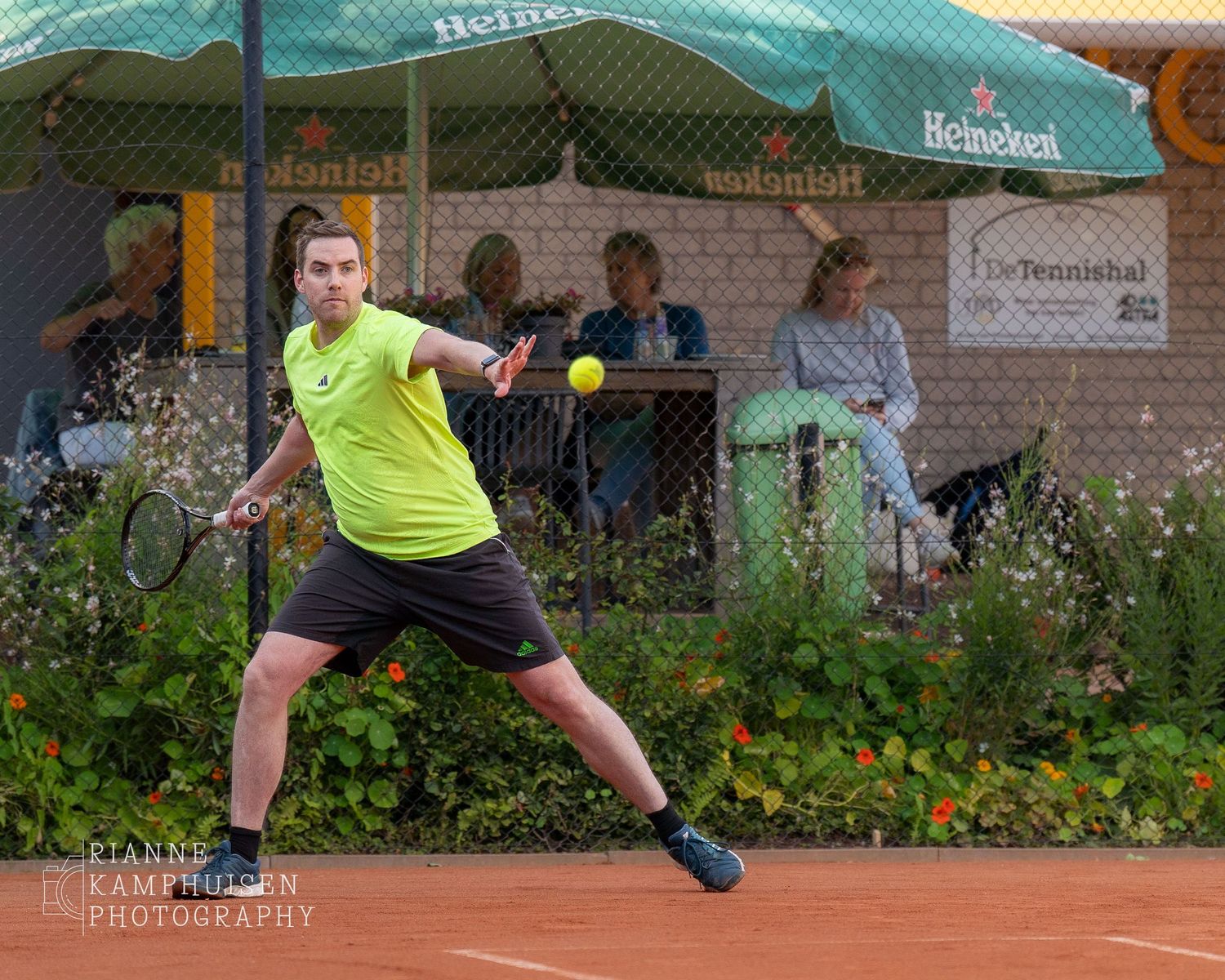 Actiefoto's van gravel tennistoernooi met spelers in actie, dubbelspel, toeschouwers en zomerse sfeer rond de baan.