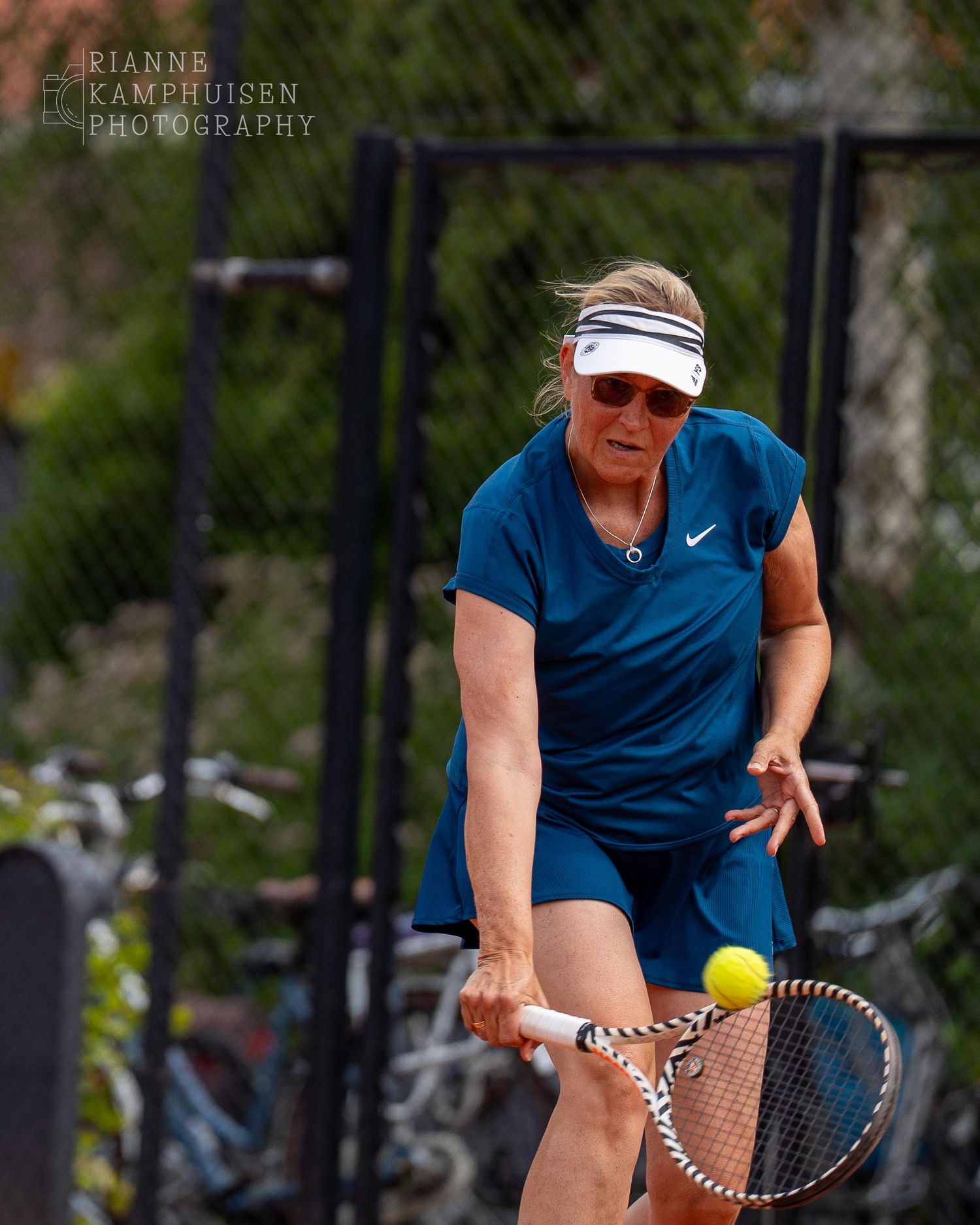 Actiefoto's van gravel tennistoernooi met spelers in actie, dubbelspel, toeschouwers en zomerse sfeer rond de baan.