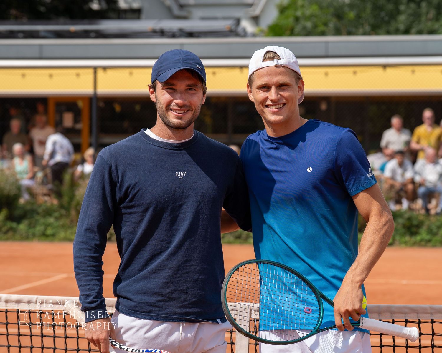 Actiefoto's en finalisten van een gravel tennistoernooi met spelers in actie, dubbelspel, toeschouwers en zomerse sfeer rond de baan.