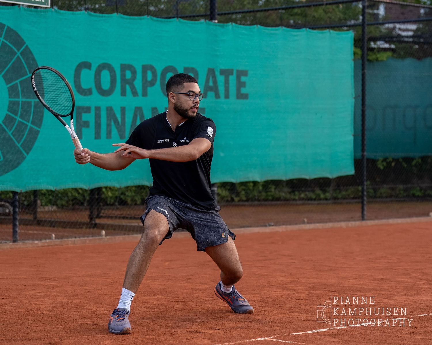 Actiefoto's van gravel tennistoernooi met spelers in actie, dubbelspel, toeschouwers en zomerse sfeer rond de baan.