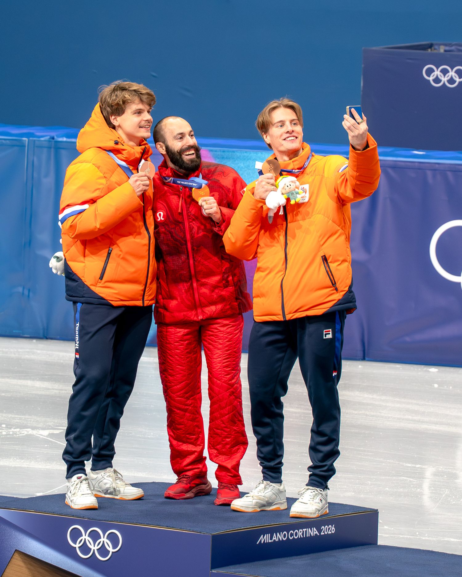 Selfie van de medaillewinnaars op het podium tijdens de huldiging van de 500m heren Shorttrack op de Olympische Spelen in Milaan, Italië