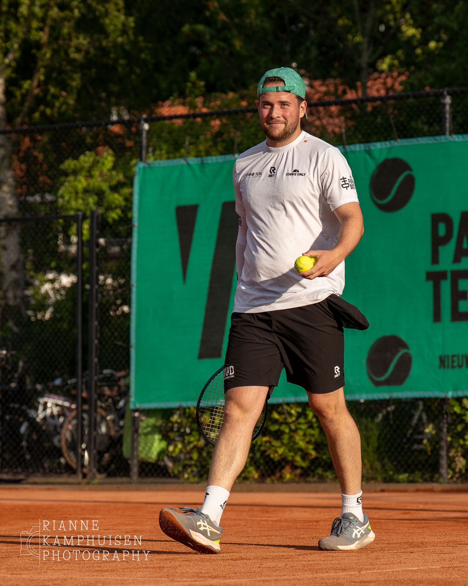 Actiefoto's van gravel tennistoernooi met spelers in actie, dubbelspel, toeschouwers en zomerse sfeer rond de baan.