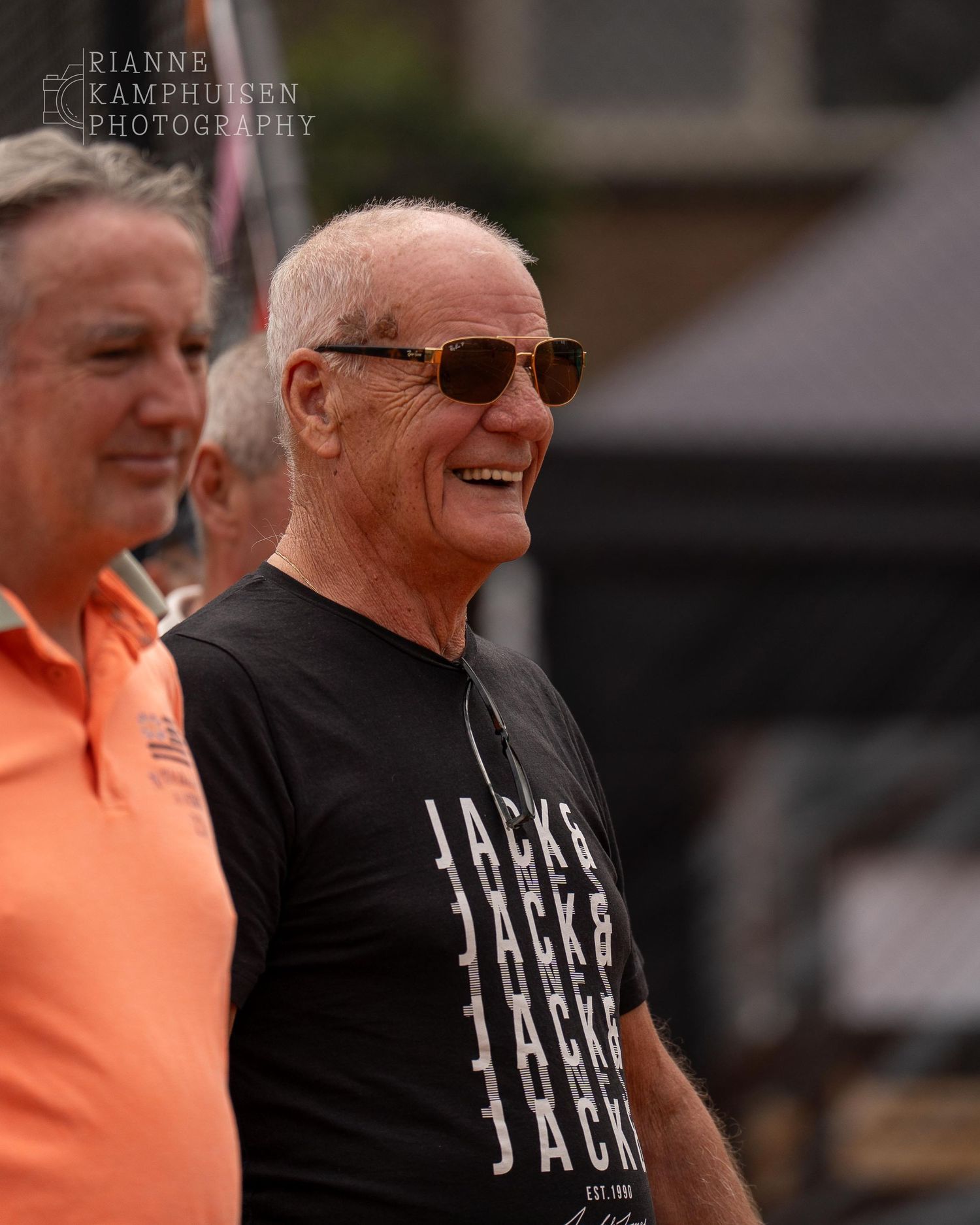 Actiefoto's van gravel tennistoernooi met spelers in actie, dubbelspel, toeschouwers en zomerse sfeer rond de baan.