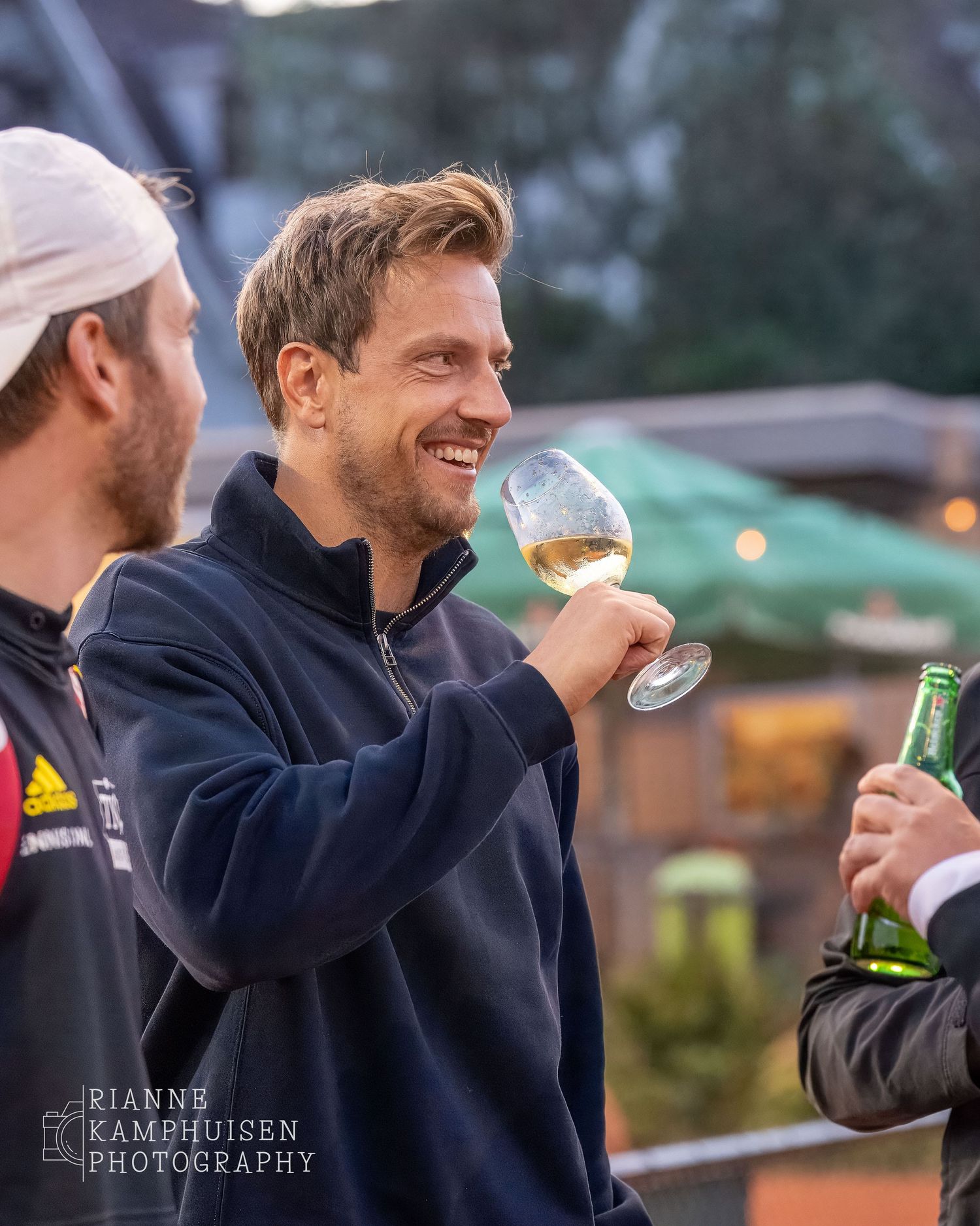 Actiefoto's van gravel tennistoernooi met spelers in actie, dubbelspel, toeschouwers en zomerse sfeer rond de baan.