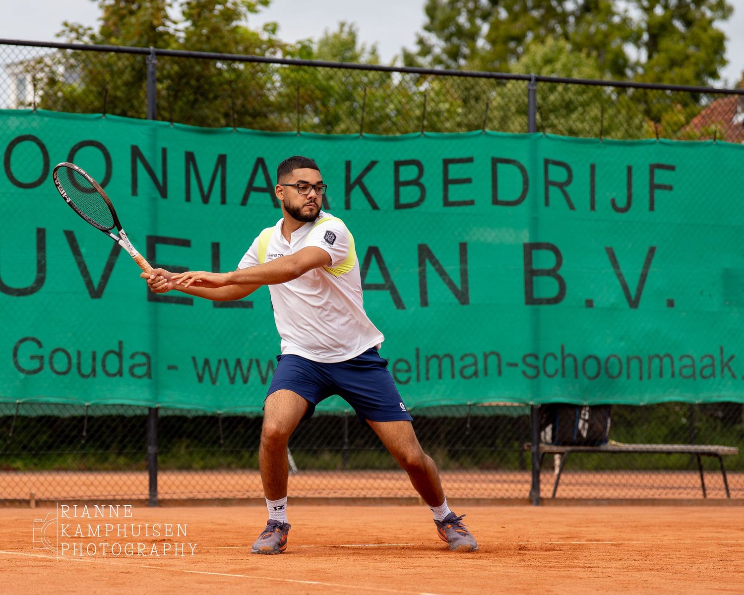 Actiefoto's en finalisten van een gravel tennistoernooi met spelers in actie, dubbelspel, toeschouwers en zomerse sfeer rond de baan.