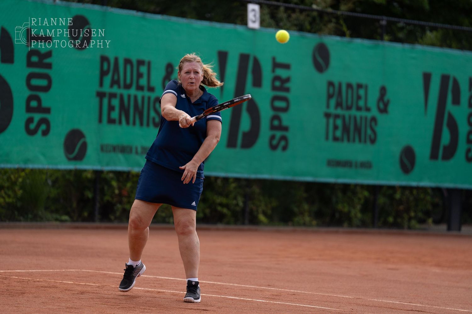 Actiefoto's van gravel tennistoernooi met spelers in actie, dubbelspel, toeschouwers en zomerse sfeer rond de baan.