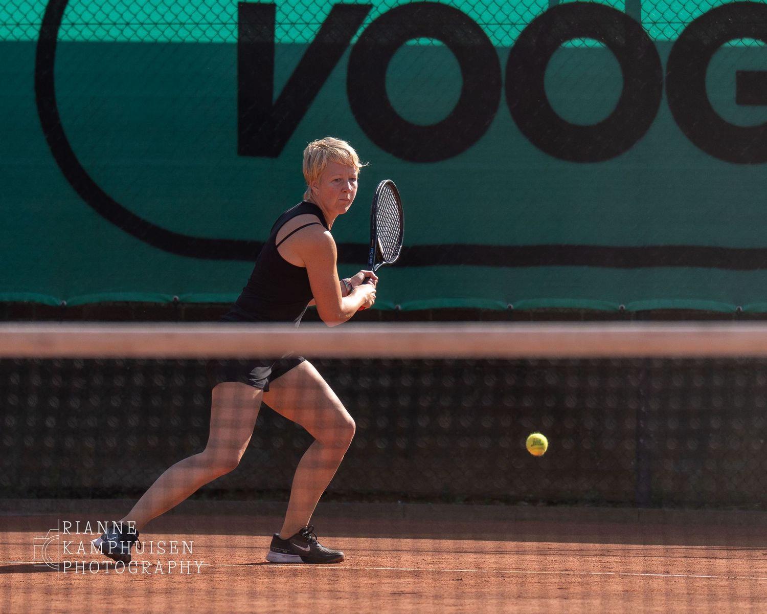 Actiefoto's en finalisten van een gravel tennistoernooi met spelers in actie, dubbelspel, toeschouwers en zomerse sfeer rond de baan.