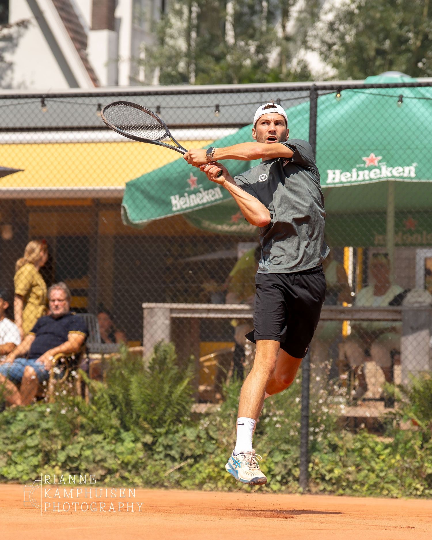 Actiefoto's en finalisten van een gravel tennistoernooi met spelers in actie, dubbelspel, toeschouwers en zomerse sfeer rond de baan.