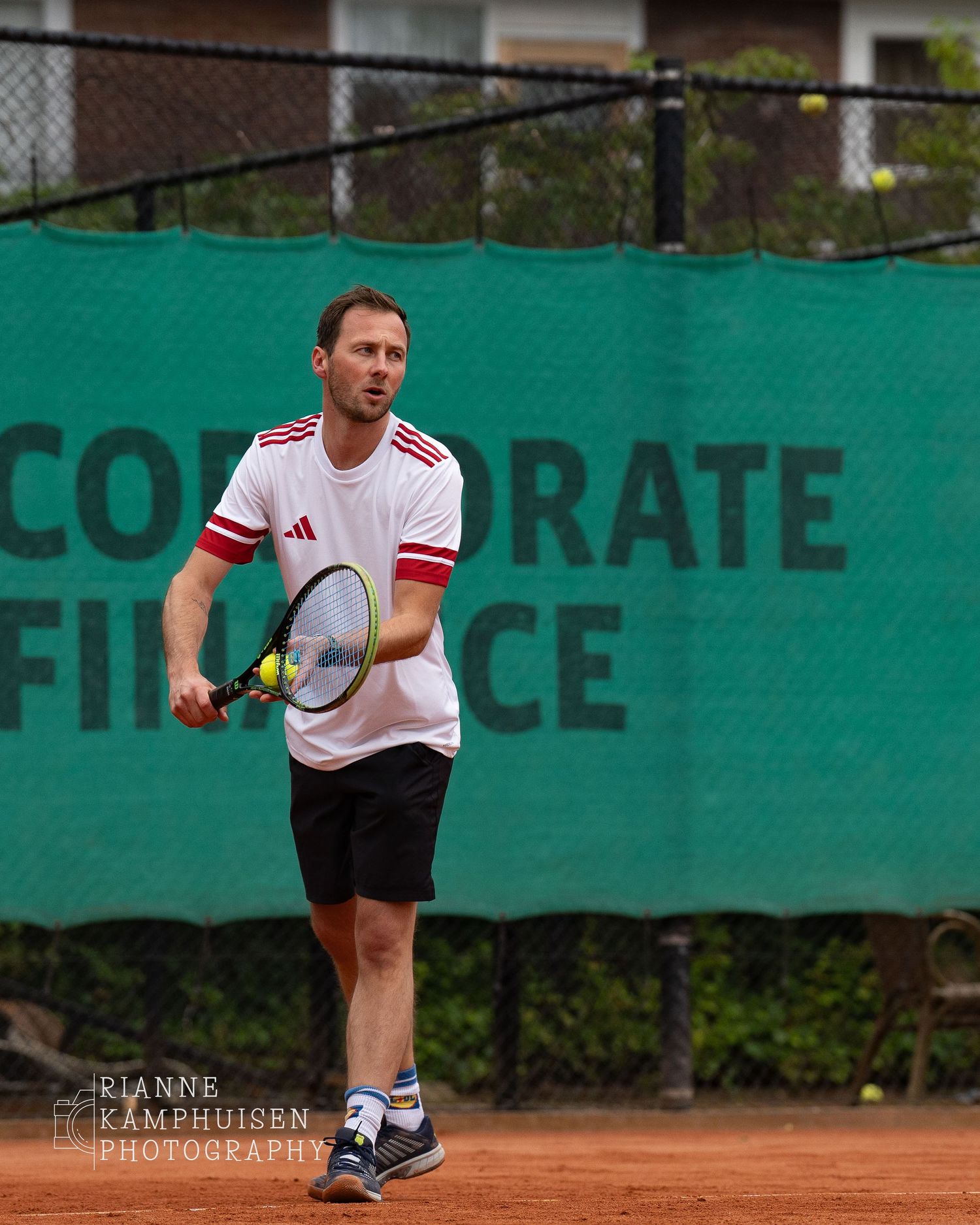 Actiefoto's en finalisten van een gravel tennistoernooi met spelers in actie, dubbelspel, toeschouwers en zomerse sfeer rond de baan.
