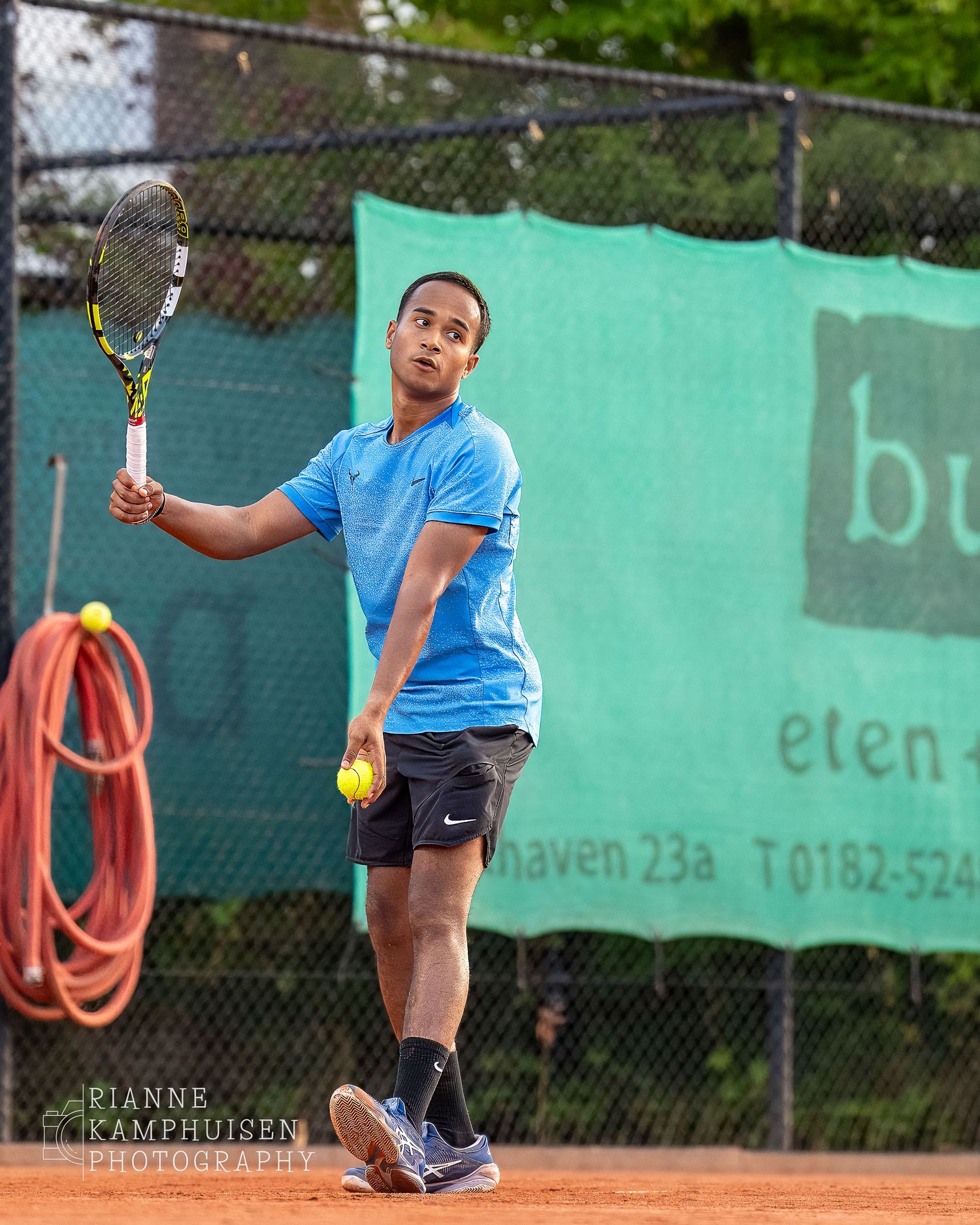 Actiefoto's van gravel tennistoernooi met spelers in actie, dubbelspel, toeschouwers en zomerse sfeer rond de baan.