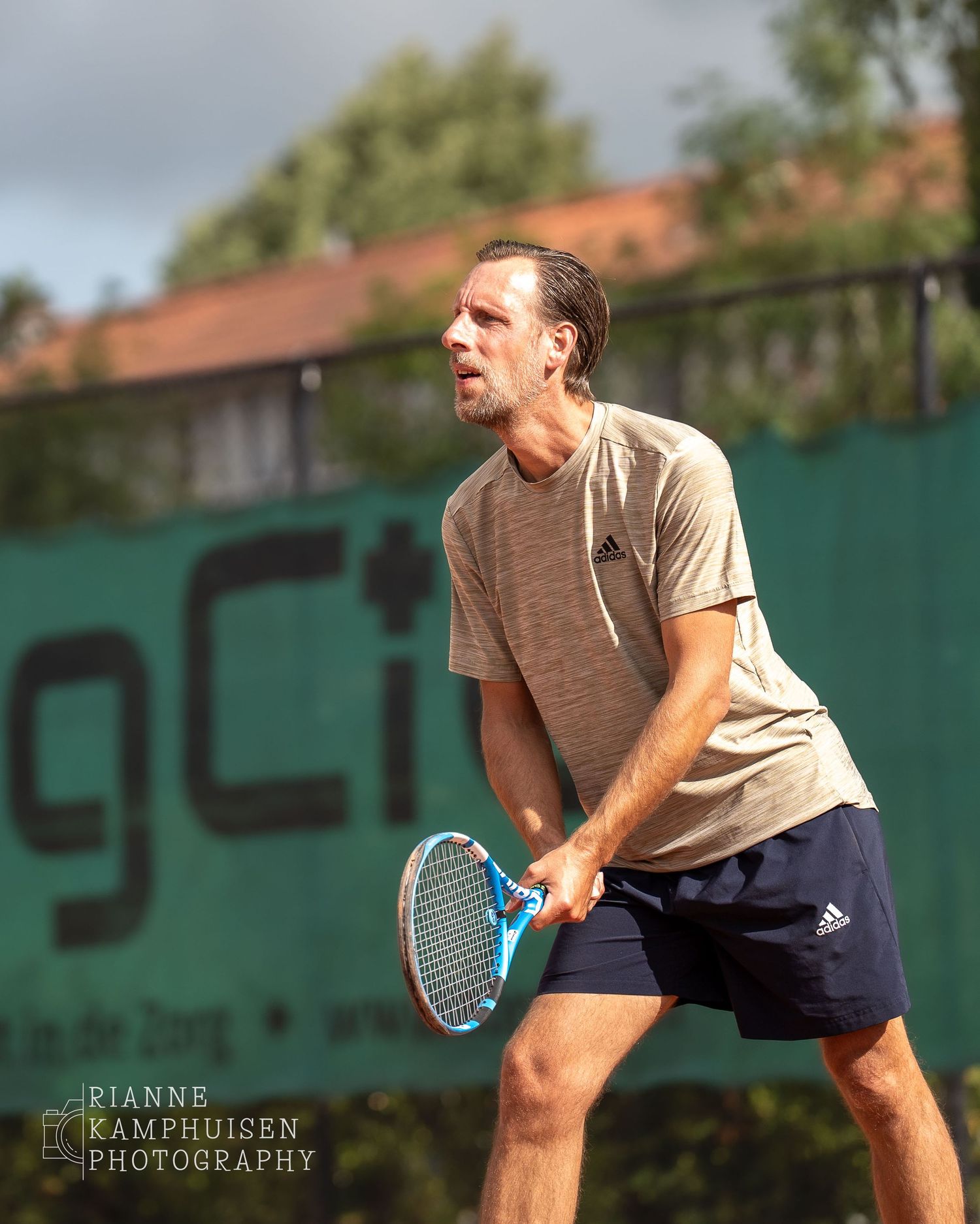 Actiefoto's van gravel tennistoernooi met spelers in actie, dubbelspel, toeschouwers en zomerse sfeer rond de baan.