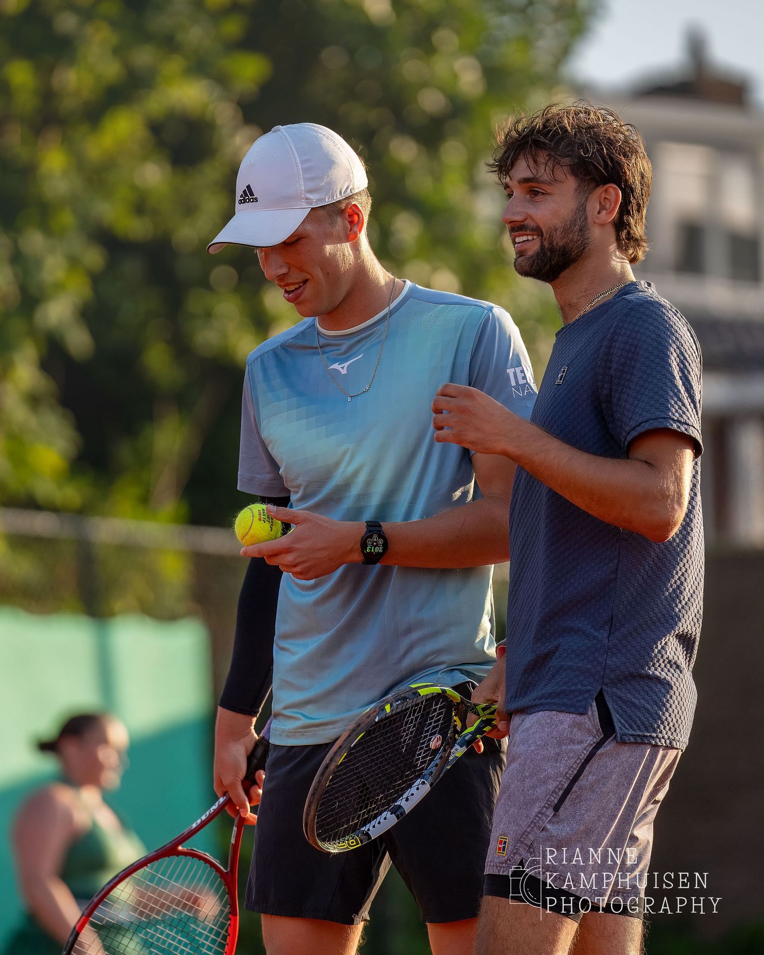 Actiefoto's van de woensdagavond van eengravel tennistoernooi met spelers in actie, dubbelspel, toeschouwers en zomerse sfeer rond de baan.