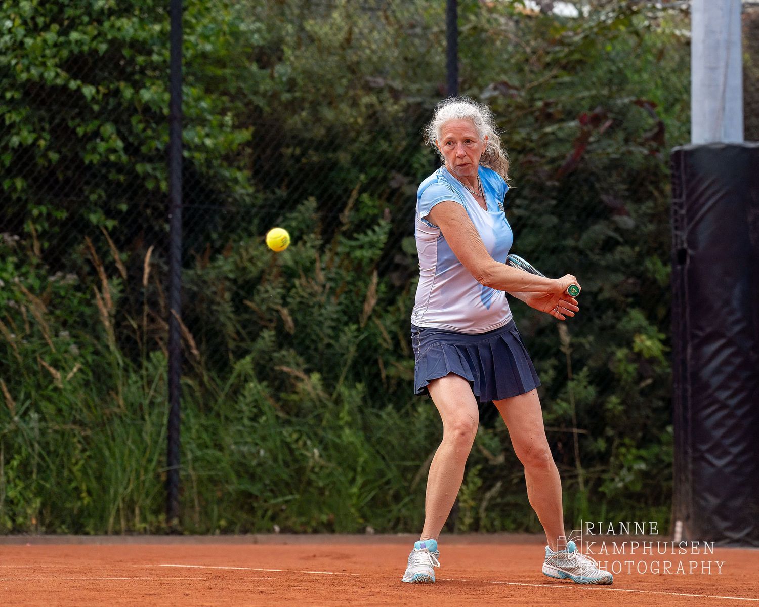 Actiefoto's van de woensdagavond van eengravel tennistoernooi met spelers in actie, dubbelspel, toeschouwers en zomerse sfeer rond de baan.