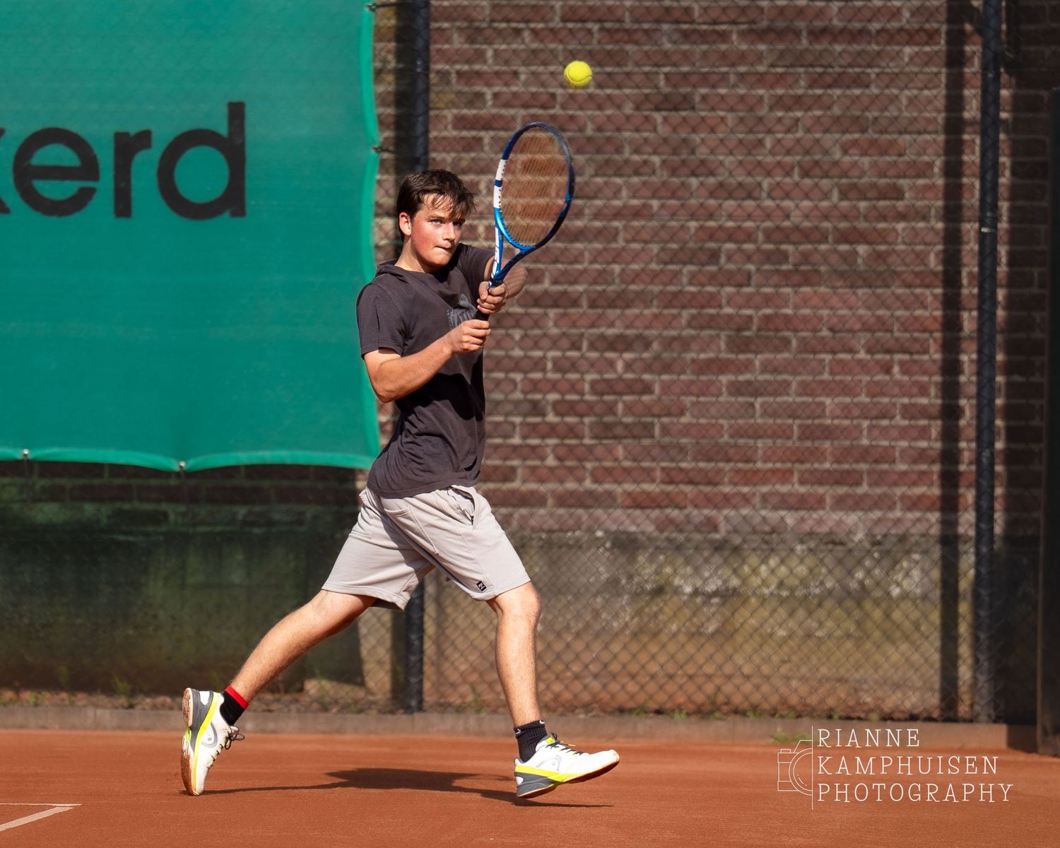 Actiefoto's van de woensdagavond van eengravel tennistoernooi met spelers in actie, dubbelspel, toeschouwers en zomerse sfeer rond de baan.