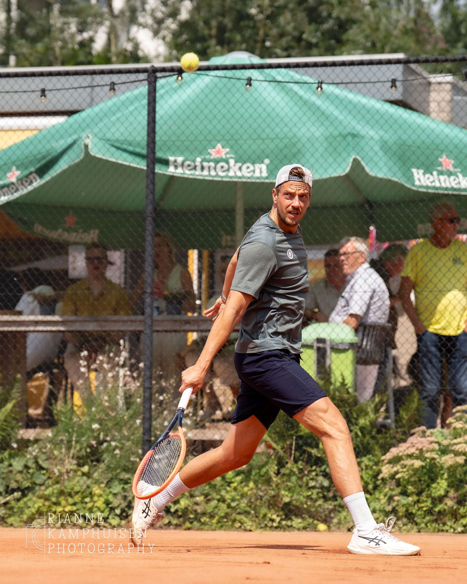 Actiefoto's en finalisten van een gravel tennistoernooi met spelers in actie, dubbelspel, toeschouwers en zomerse sfeer rond de baan.