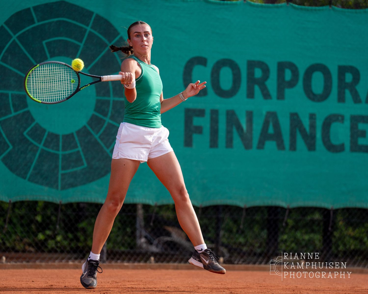 Actiefoto's van gravel tennistoernooi met spelers in actie, dubbelspel, toeschouwers en zomerse sfeer rond de baan.