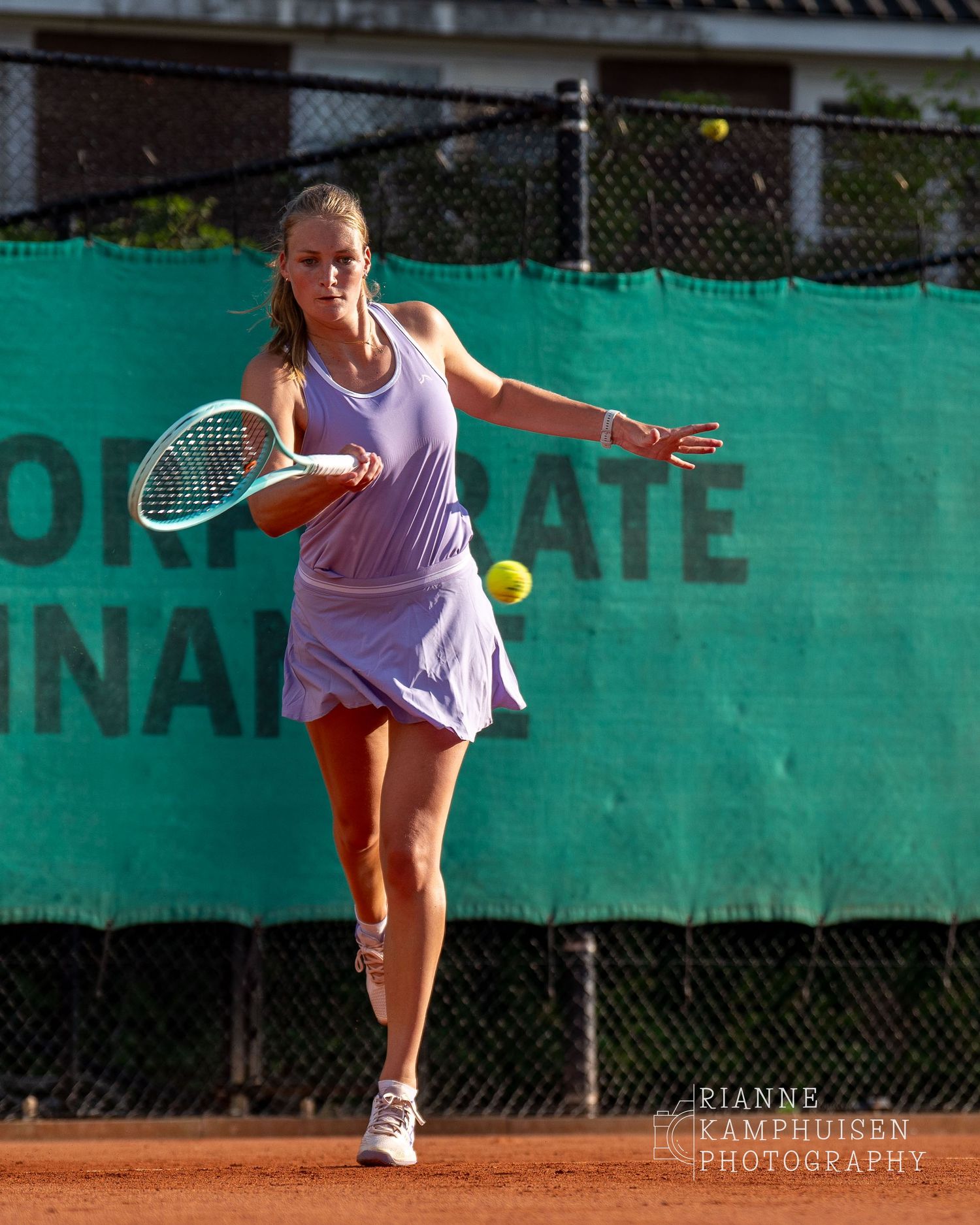 Actiefoto's van de woensdagavond van eengravel tennistoernooi met spelers in actie, dubbelspel, toeschouwers en zomerse sfeer rond de baan.