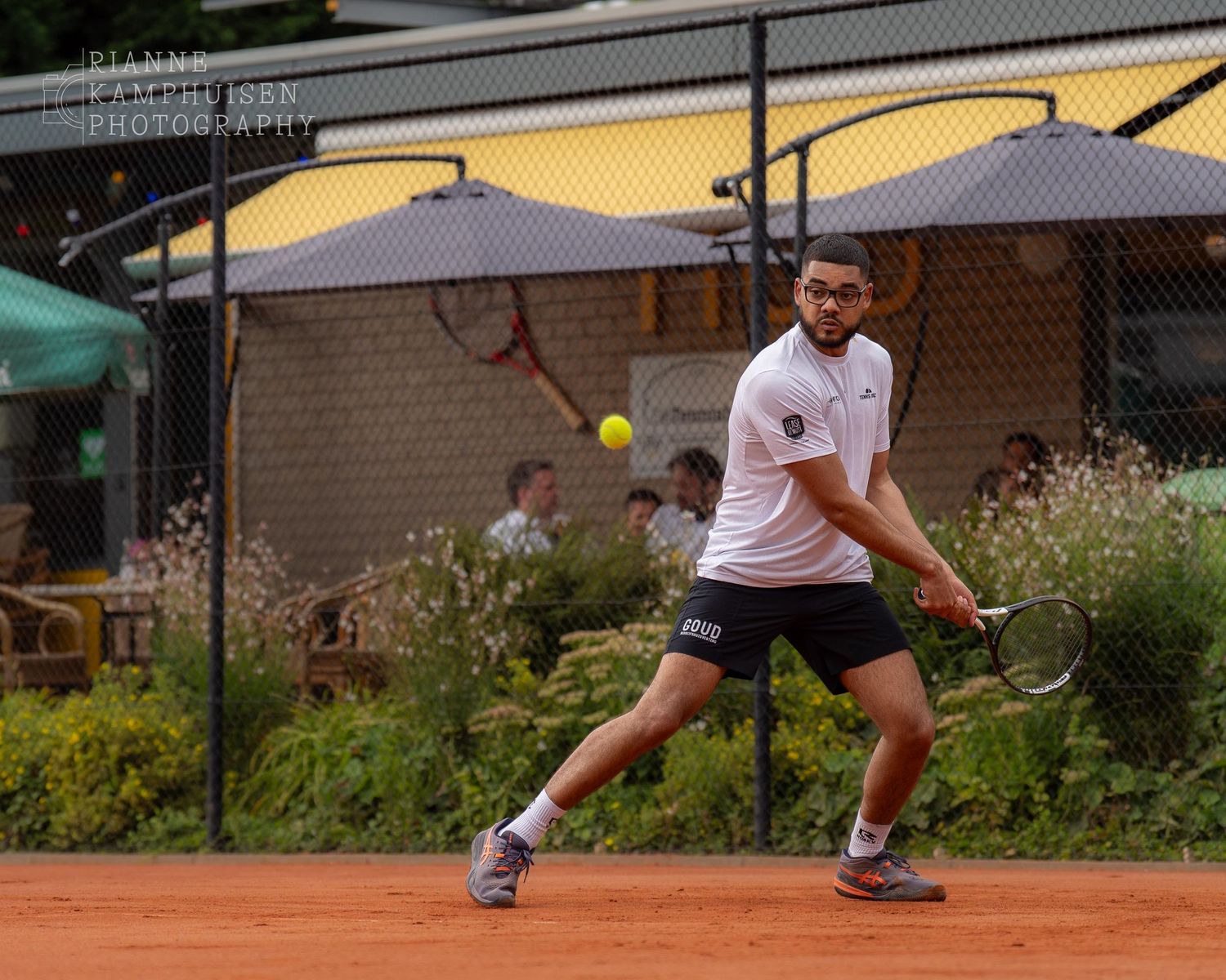 Actiefoto's van gravel tennistoernooi met spelers in actie, dubbelspel, toeschouwers en zomerse sfeer rond de baan.