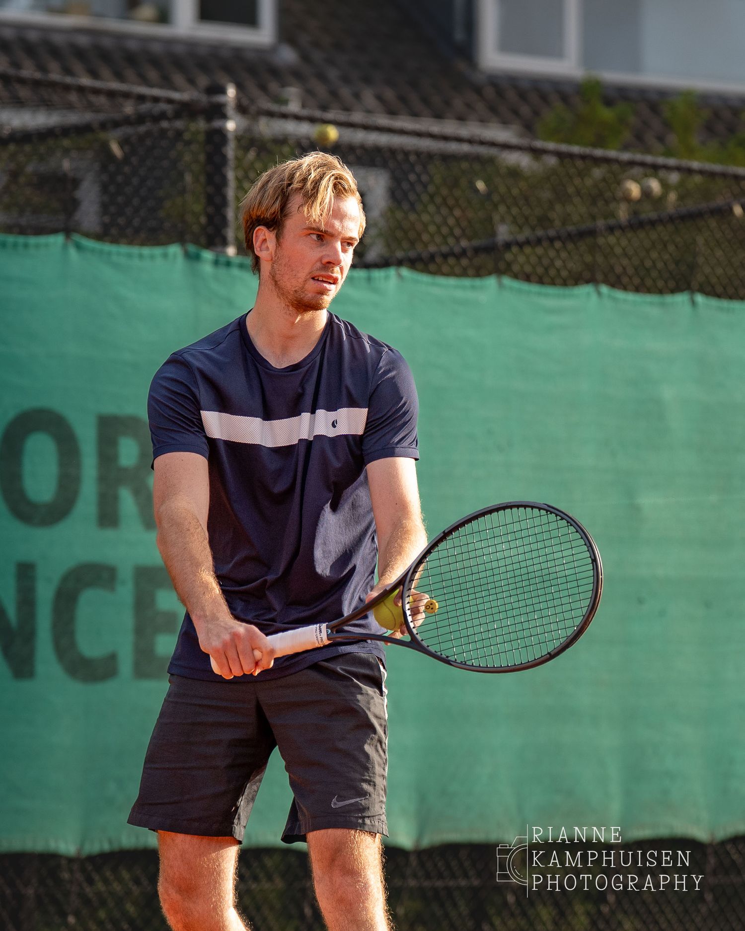 Actiefoto's van de vrijdagavond van een gravel tennistoernooi met spelers in actie, dubbelspel, toeschouwers en zomerse sfeer rond de baan.