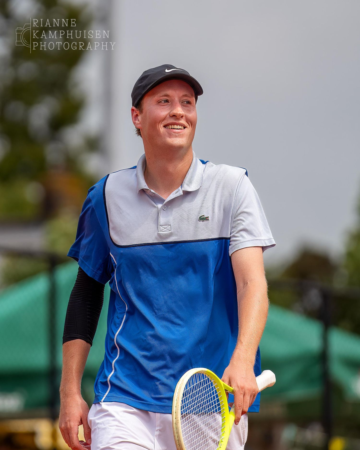 Actiefoto's van gravel tennistoernooi met spelers in actie, dubbelspel, toeschouwers en zomerse sfeer rond de baan.