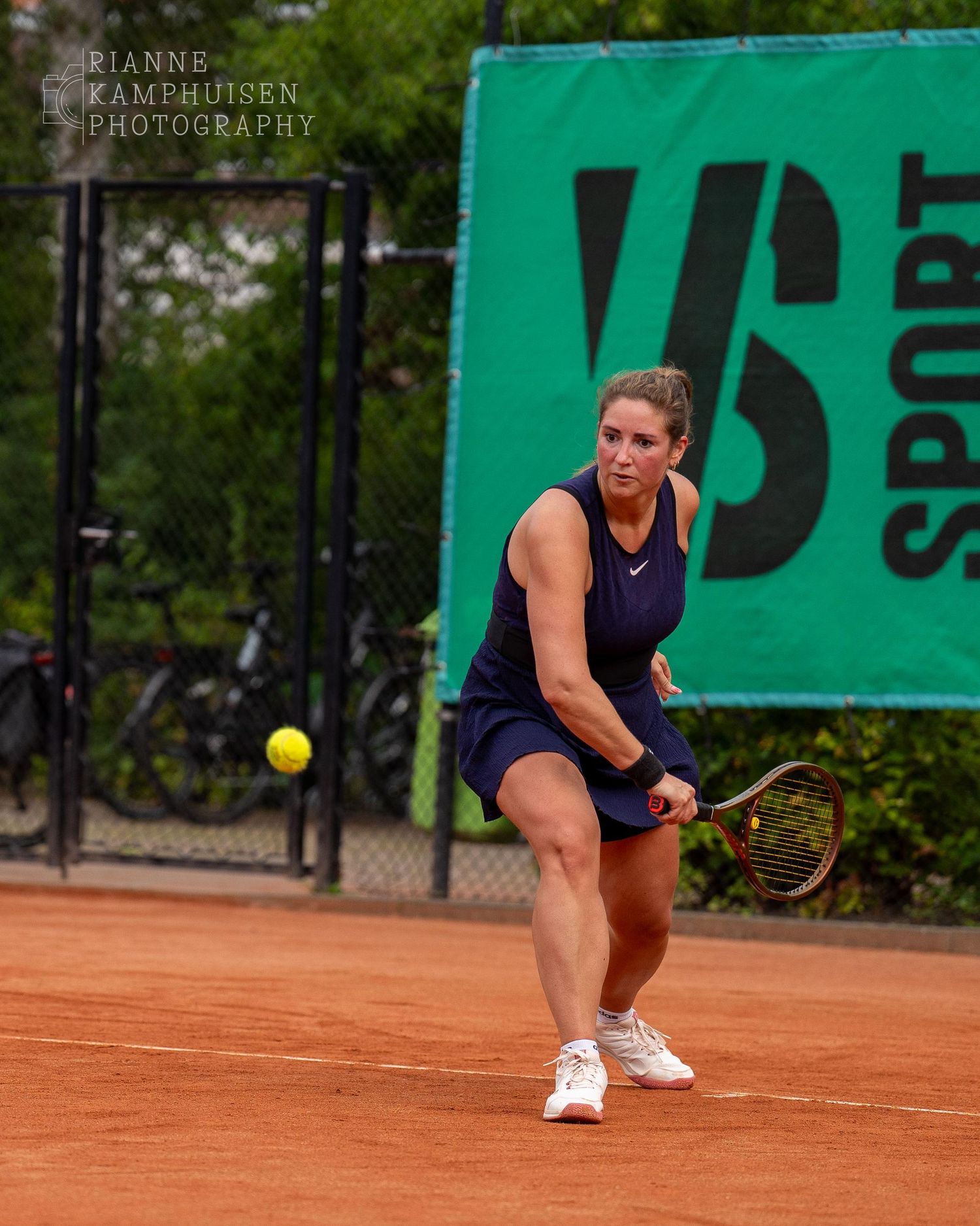 Actiefoto's van gravel tennistoernooi met spelers in actie, dubbelspel, toeschouwers en zomerse sfeer rond de baan.