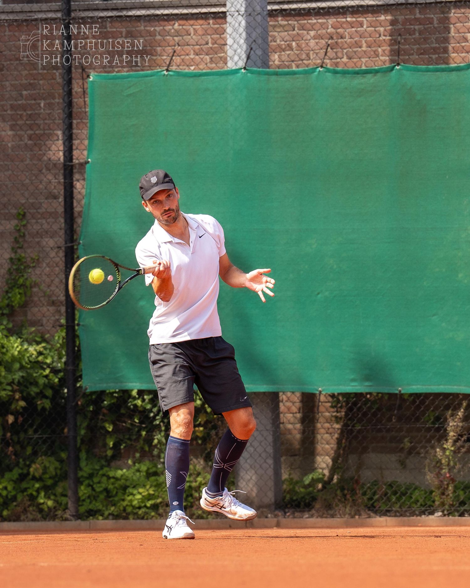 Actiefoto's van gravel tennistoernooi met spelers in actie, dubbelspel, toeschouwers en zomerse sfeer rond de baan.