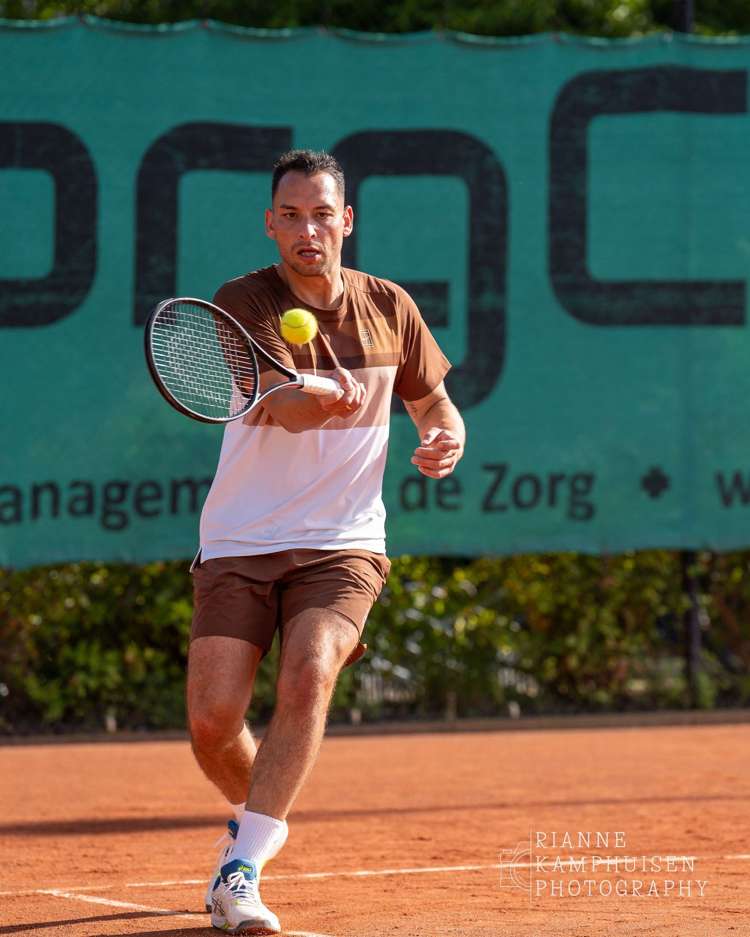 Actiefoto's van gravel tennistoernooi met spelers in actie, dubbelspel, toeschouwers en zomerse sfeer rond de baan.