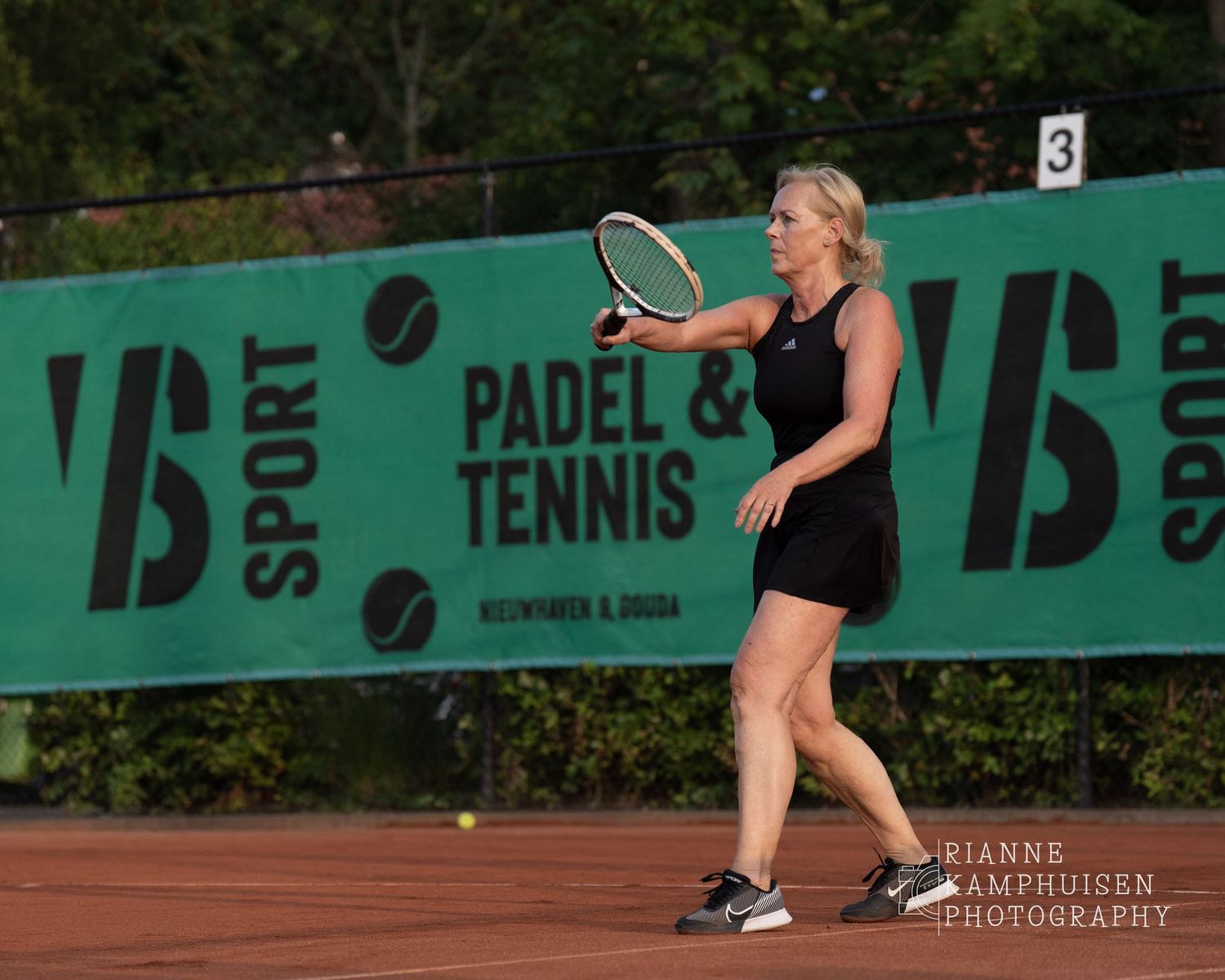Actiefoto's van gravel tennistoernooi met spelers in actie, dubbelspel, toeschouwers en zomerse sfeer rond de baan.