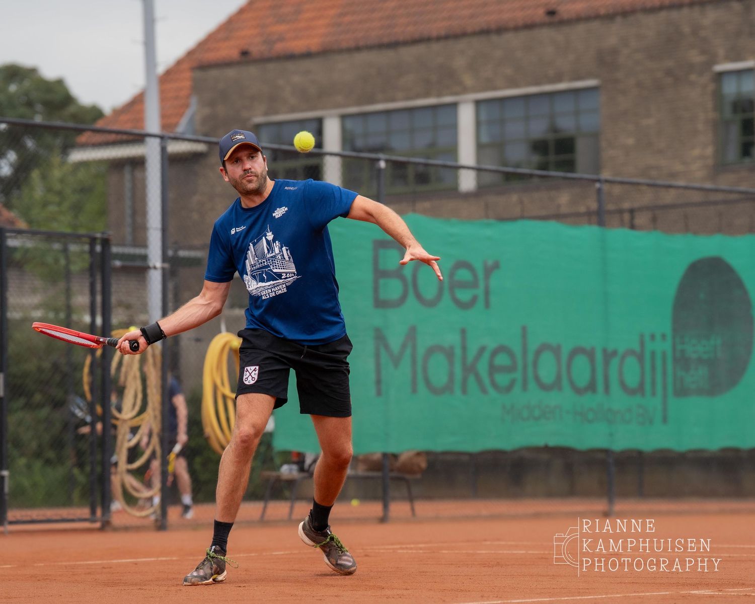 Actiefoto's van gravel tennistoernooi met spelers in actie, dubbelspel, toeschouwers en zomerse sfeer rond de baan.