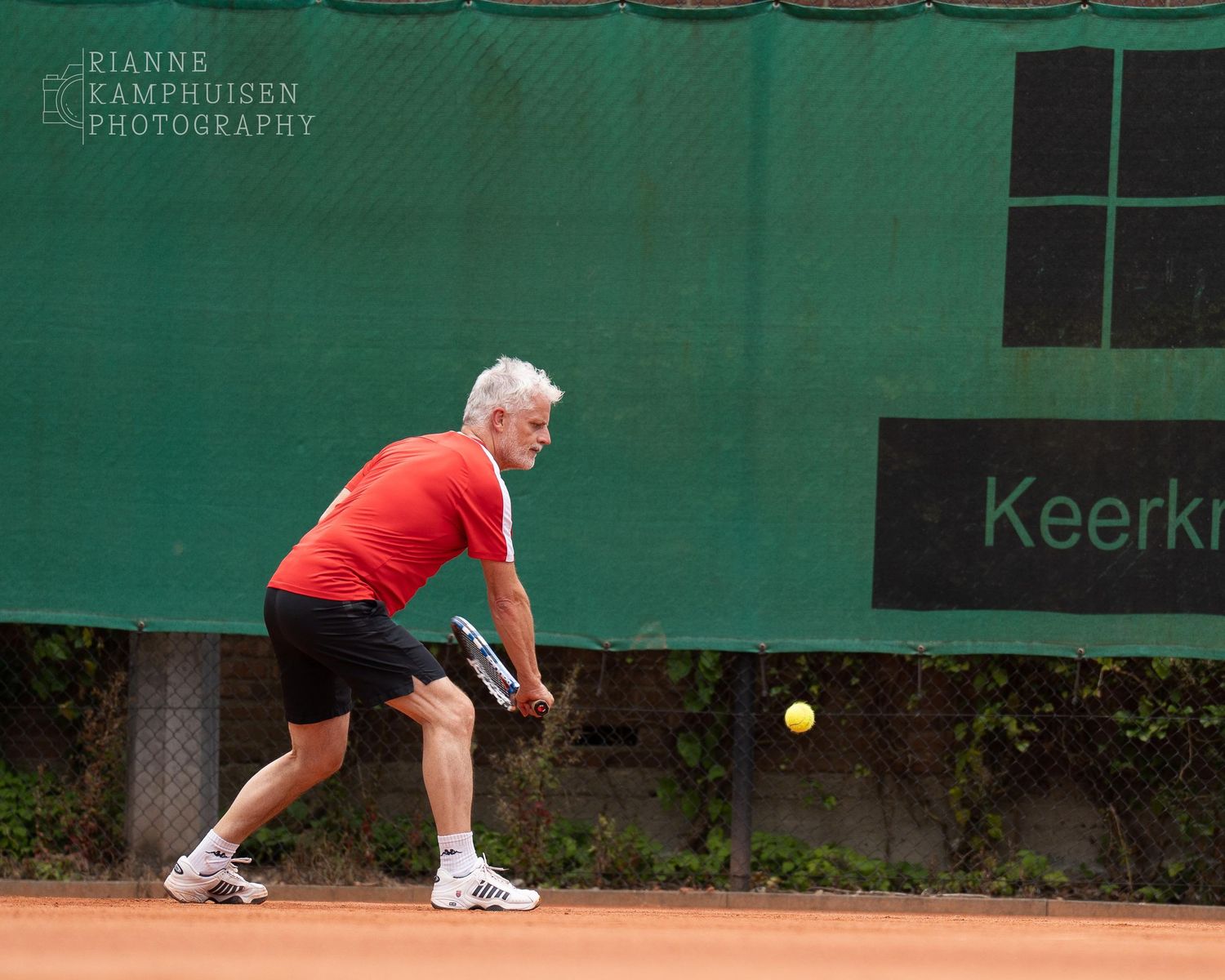 Actiefoto's van gravel tennistoernooi met spelers in actie, dubbelspel, toeschouwers en zomerse sfeer rond de baan.