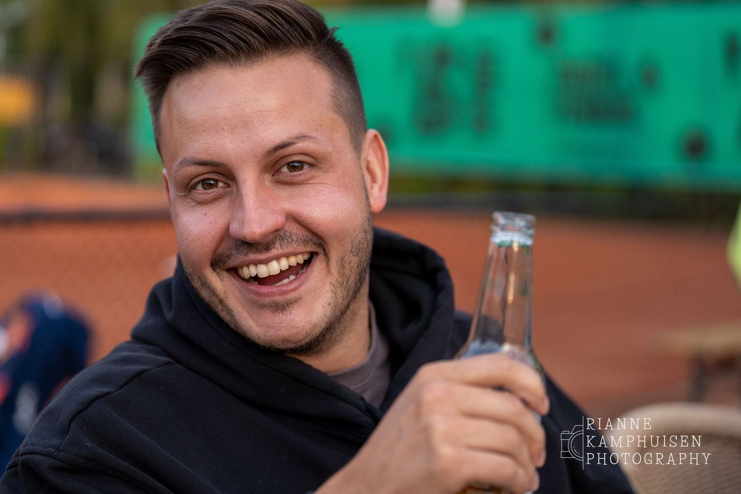 Actiefoto's van gravel tennistoernooi met spelers in actie, dubbelspel, toeschouwers en zomerse sfeer rond de baan.