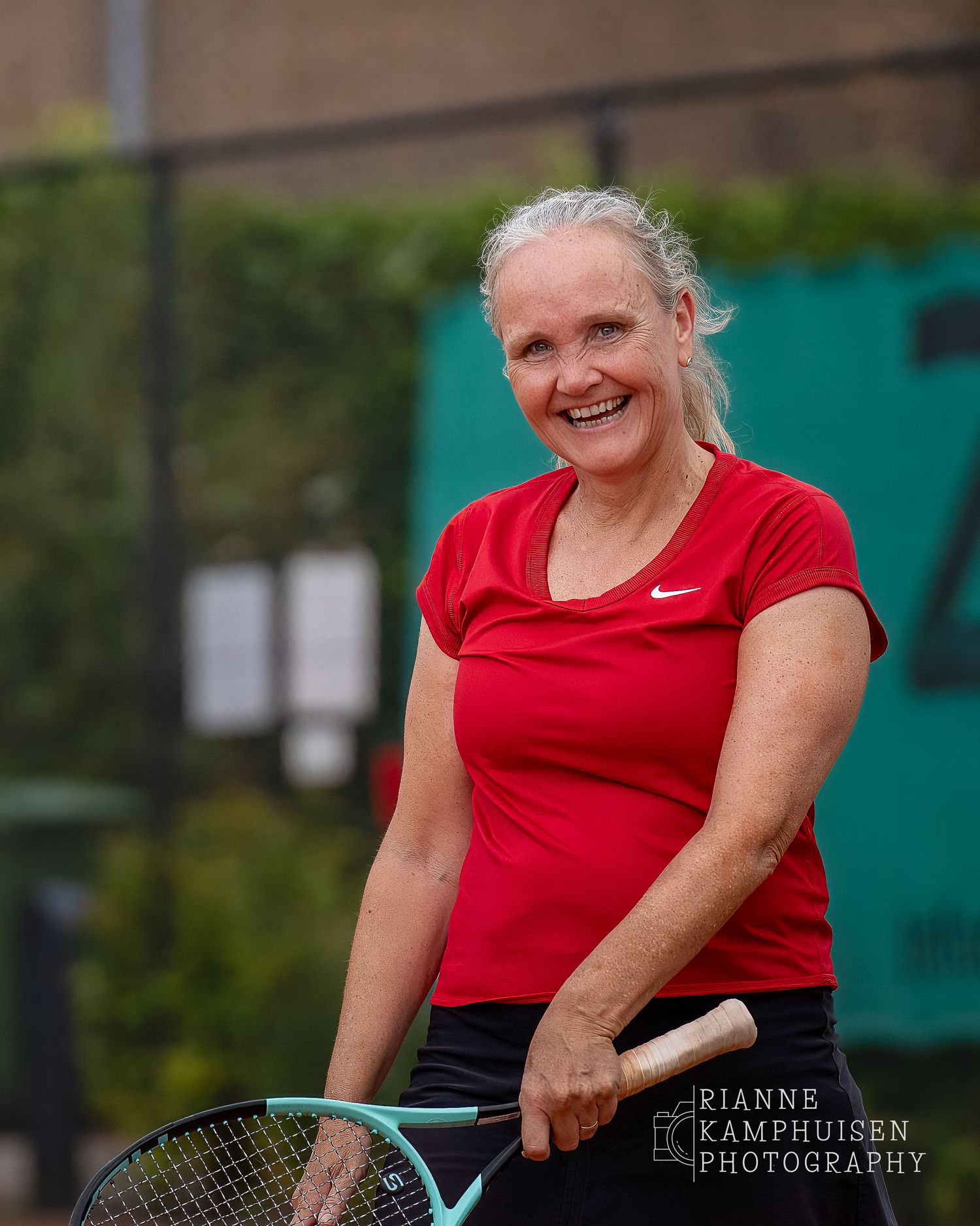 Actiefoto's van de vrijdagavond van een gravel tennistoernooi met spelers in actie, dubbelspel, toeschouwers en zomerse sfeer rond de baan.