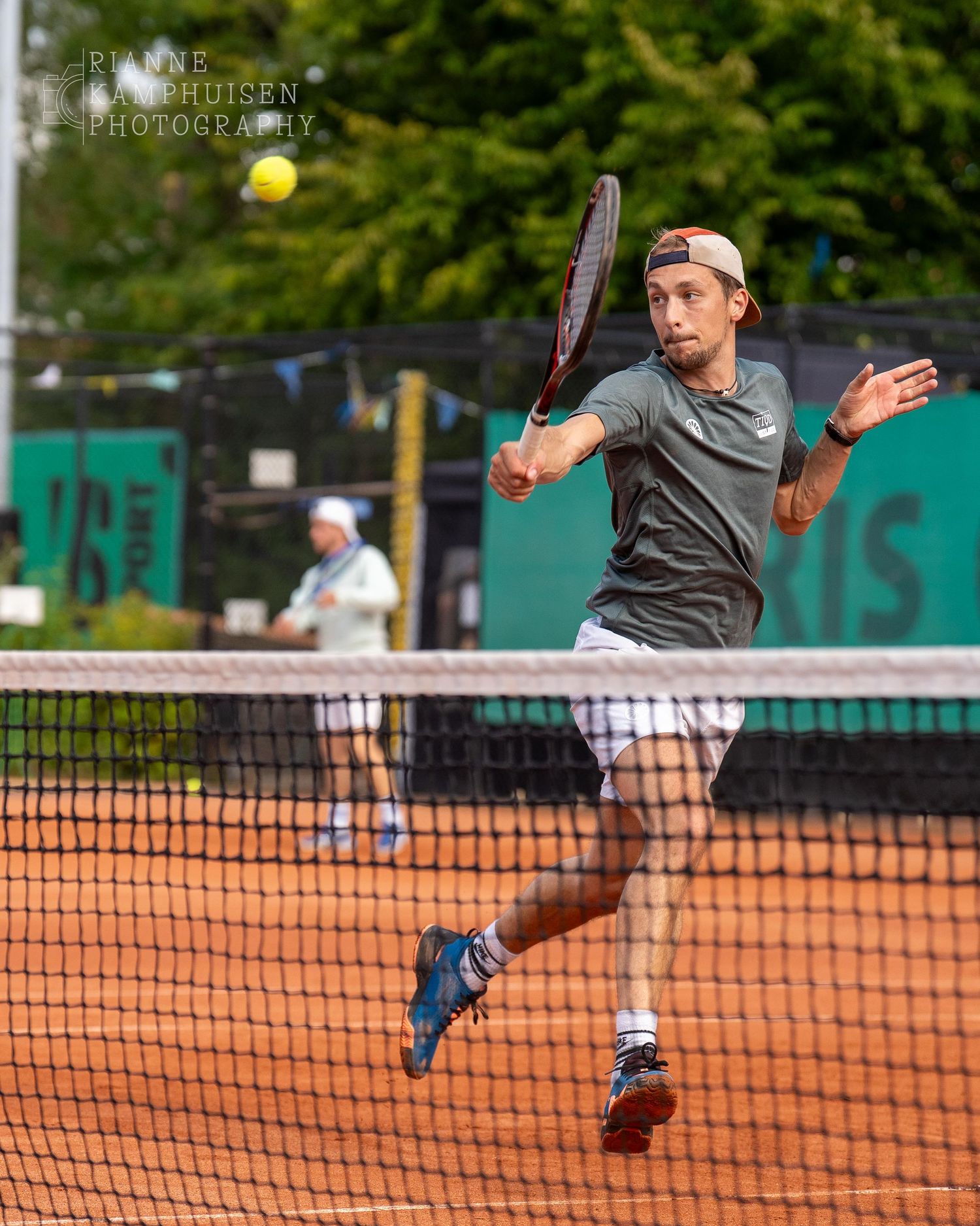 Actiefoto's van gravel tennistoernooi met spelers in actie, dubbelspel, toeschouwers en zomerse sfeer rond de baan.