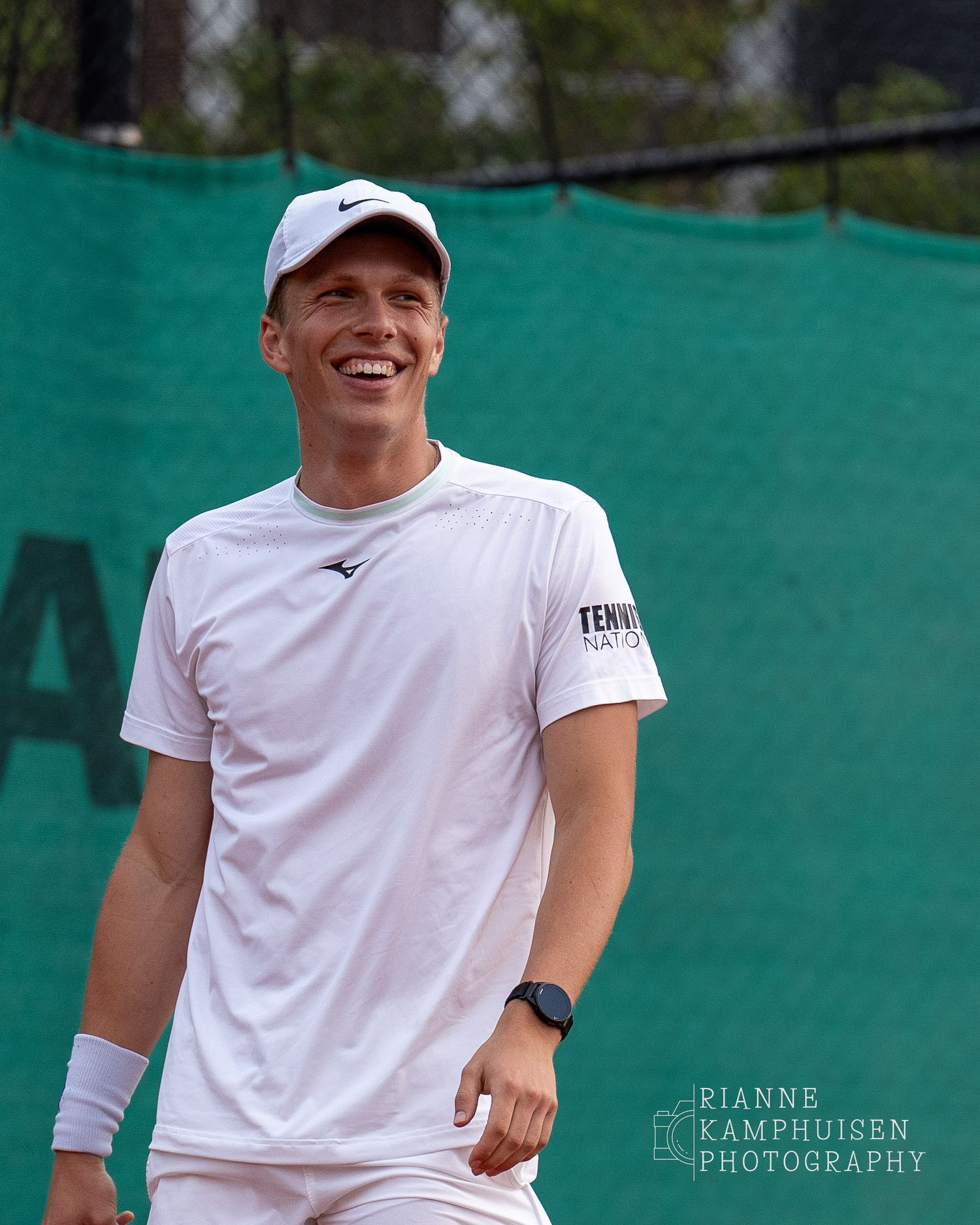 Actiefoto's van gravel tennistoernooi met spelers in actie, dubbelspel, toeschouwers en zomerse sfeer rond de baan.