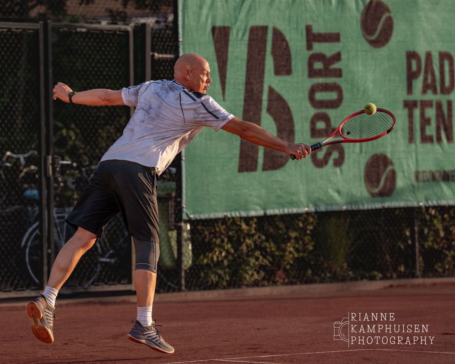 Actiefoto's van de woensdagavond van eengravel tennistoernooi met spelers in actie, dubbelspel, toeschouwers en zomerse sfeer rond de baan.