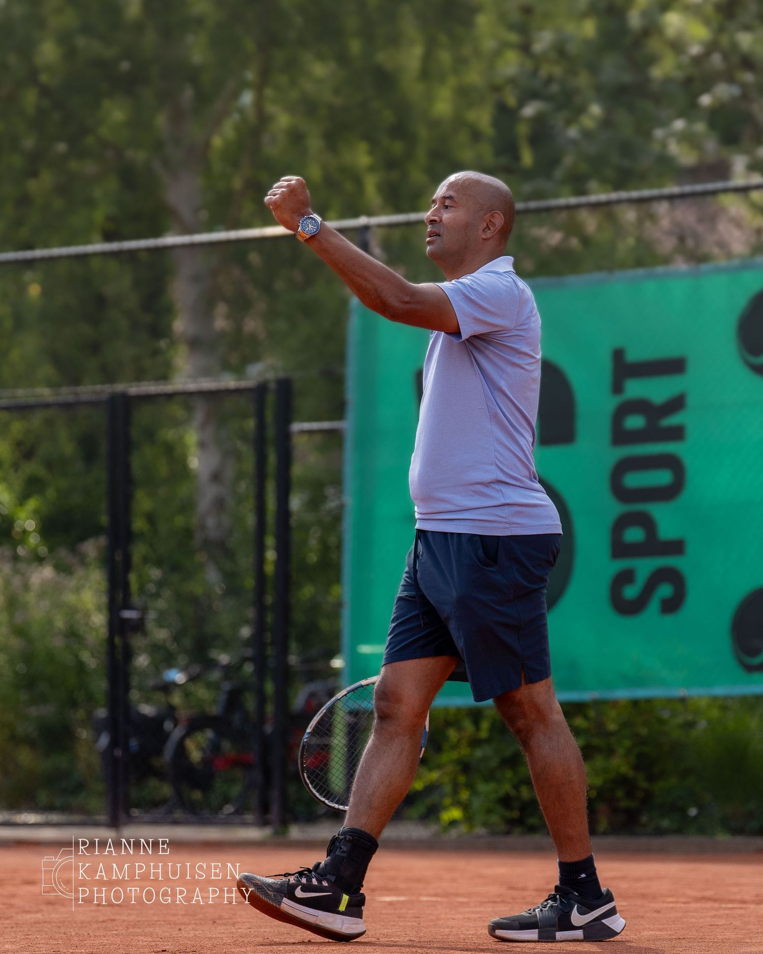 Actiefoto's en finalisten van een gravel tennistoernooi met spelers in actie, dubbelspel, toeschouwers en zomerse sfeer rond de baan.