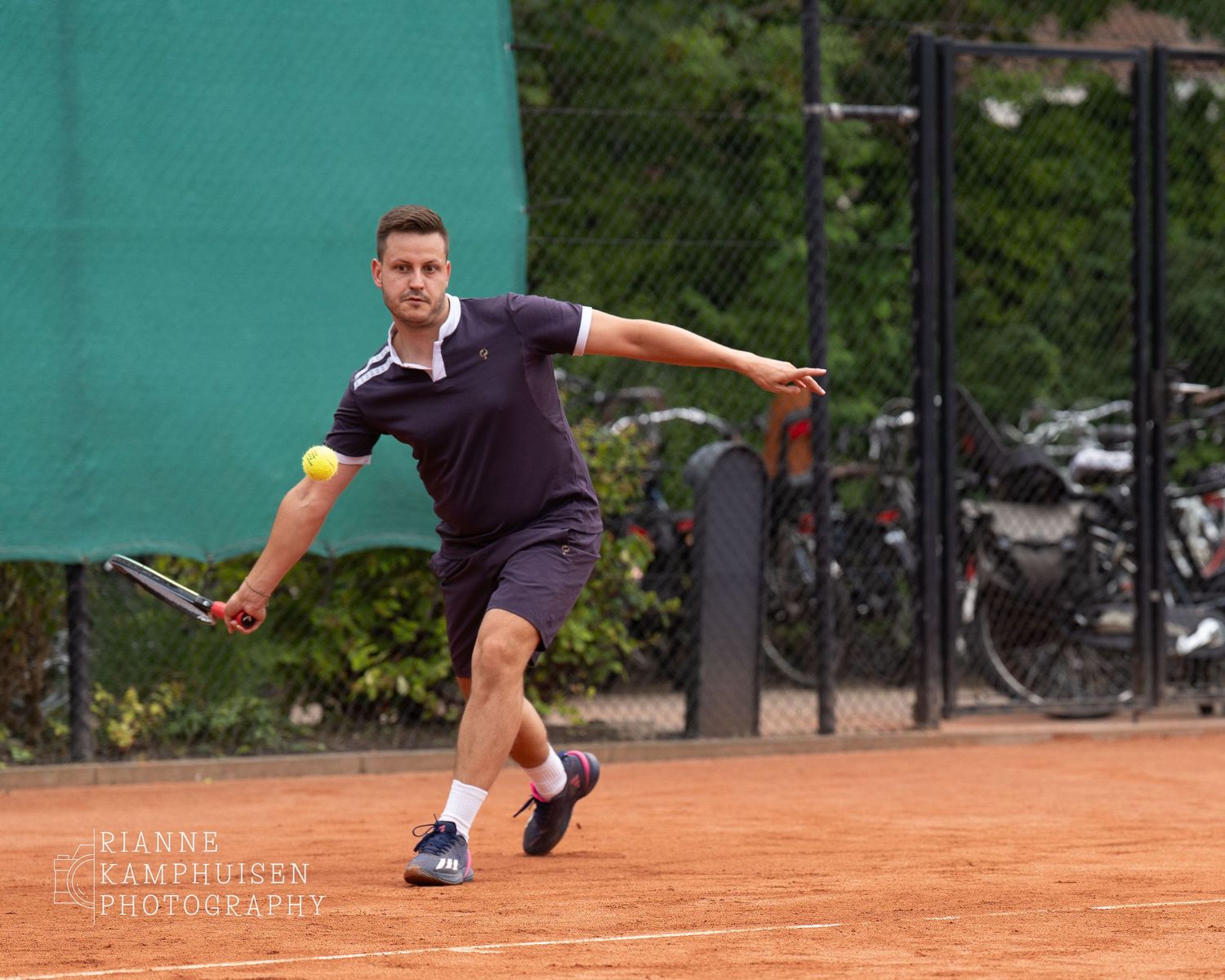 Actiefoto's en finalisten van een gravel tennistoernooi met spelers in actie, dubbelspel, toeschouwers en zomerse sfeer rond de baan.