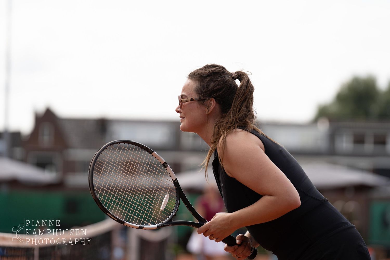 Actiefoto's van gravel tennistoernooi met spelers in actie, dubbelspel, toeschouwers en zomerse sfeer rond de baan.