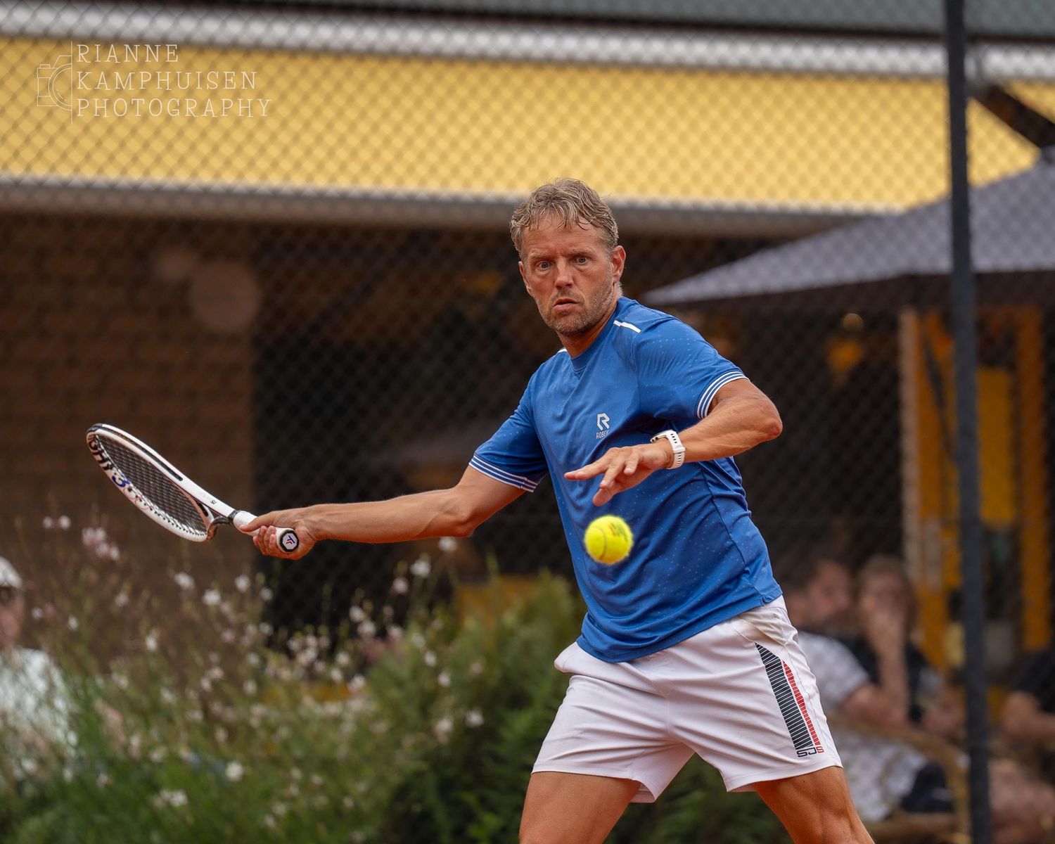Actiefoto's van gravel tennistoernooi met spelers in actie, dubbelspel, toeschouwers en zomerse sfeer rond de baan.