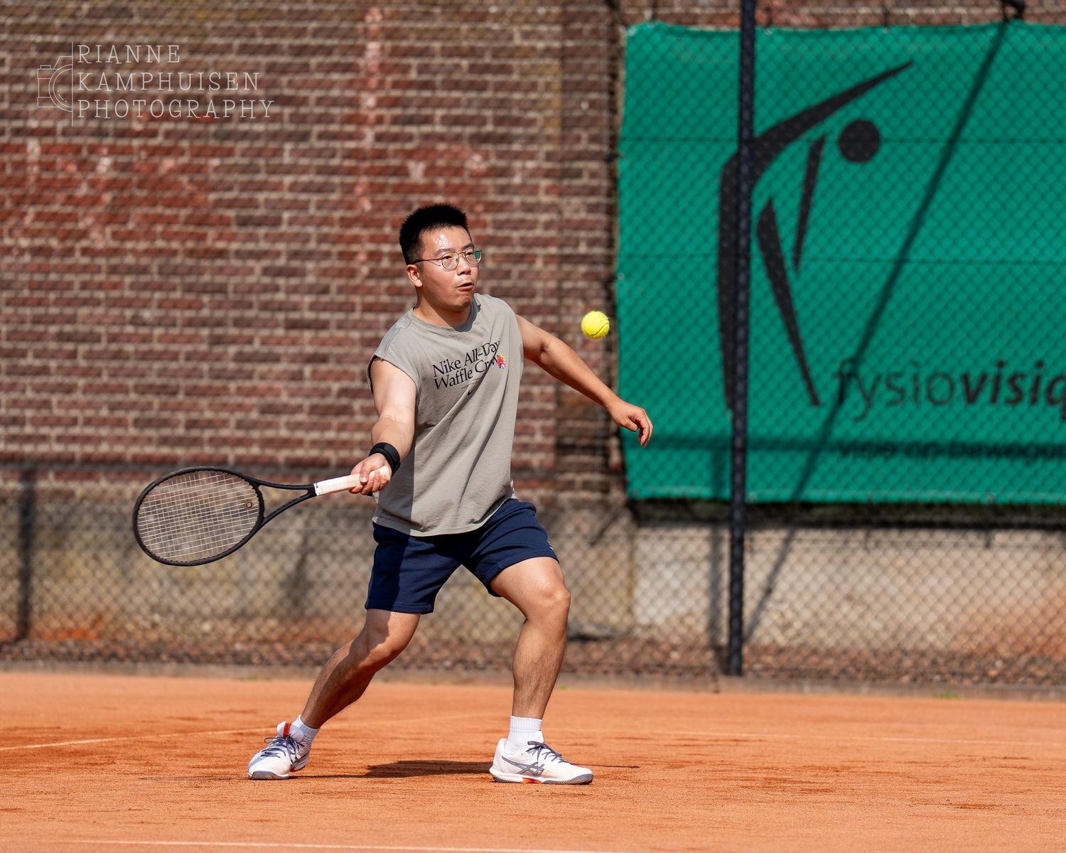 Actiefoto's van gravel tennistoernooi met spelers in actie, dubbelspel, toeschouwers en zomerse sfeer rond de baan.