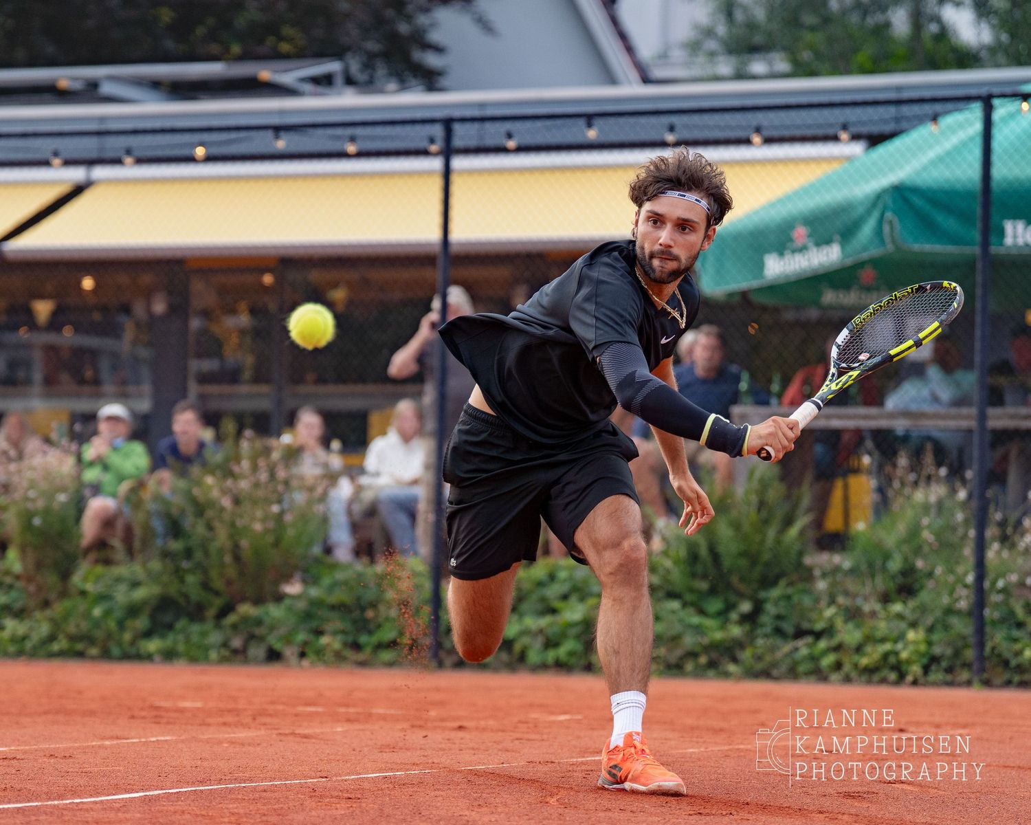 Actiefoto's van gravel tennistoernooi met spelers in actie, dubbelspel, toeschouwers en zomerse sfeer rond de baan.