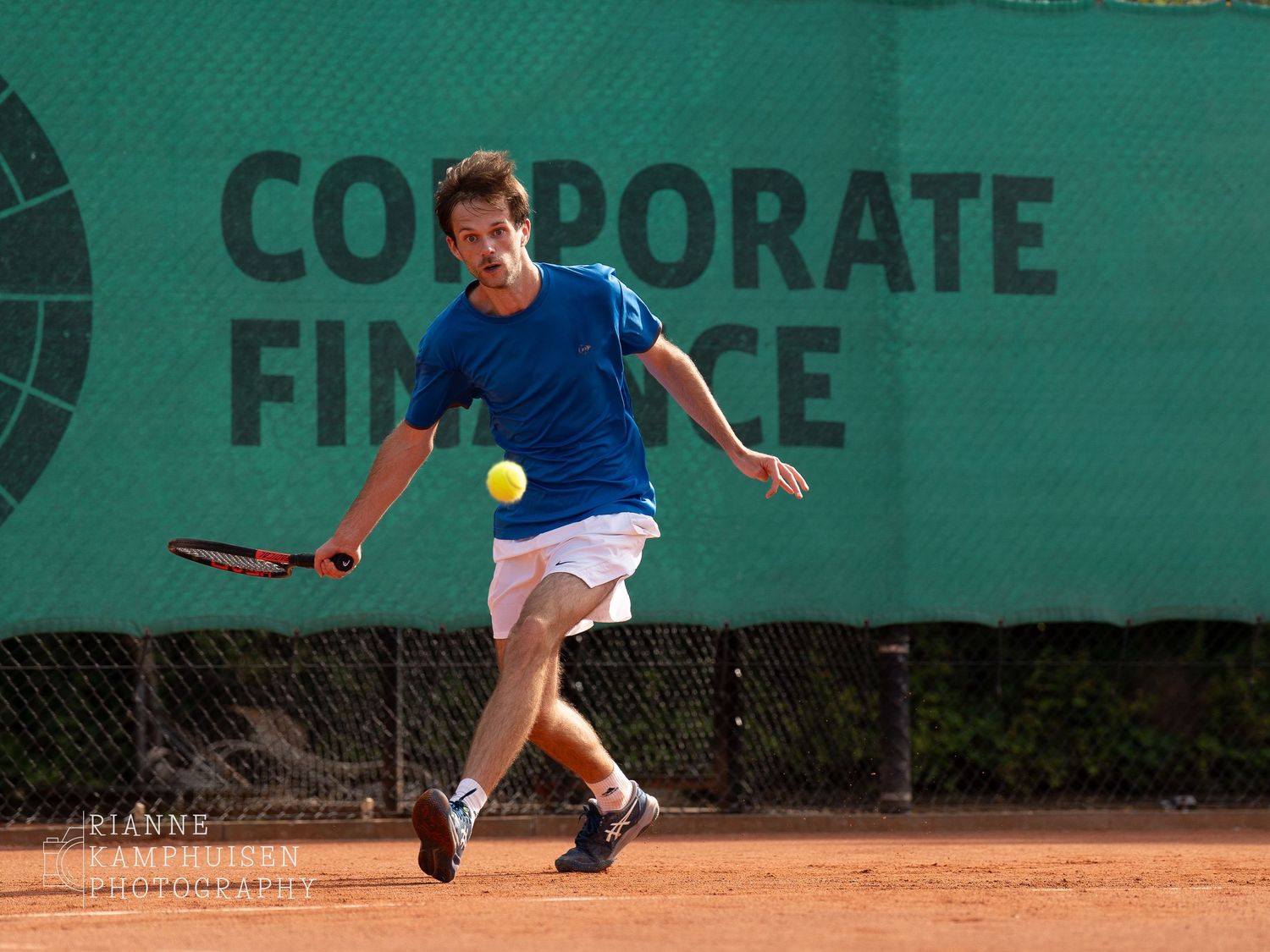 Actiefoto's van gravel tennistoernooi met spelers in actie, dubbelspel, toeschouwers en zomerse sfeer rond de baan.