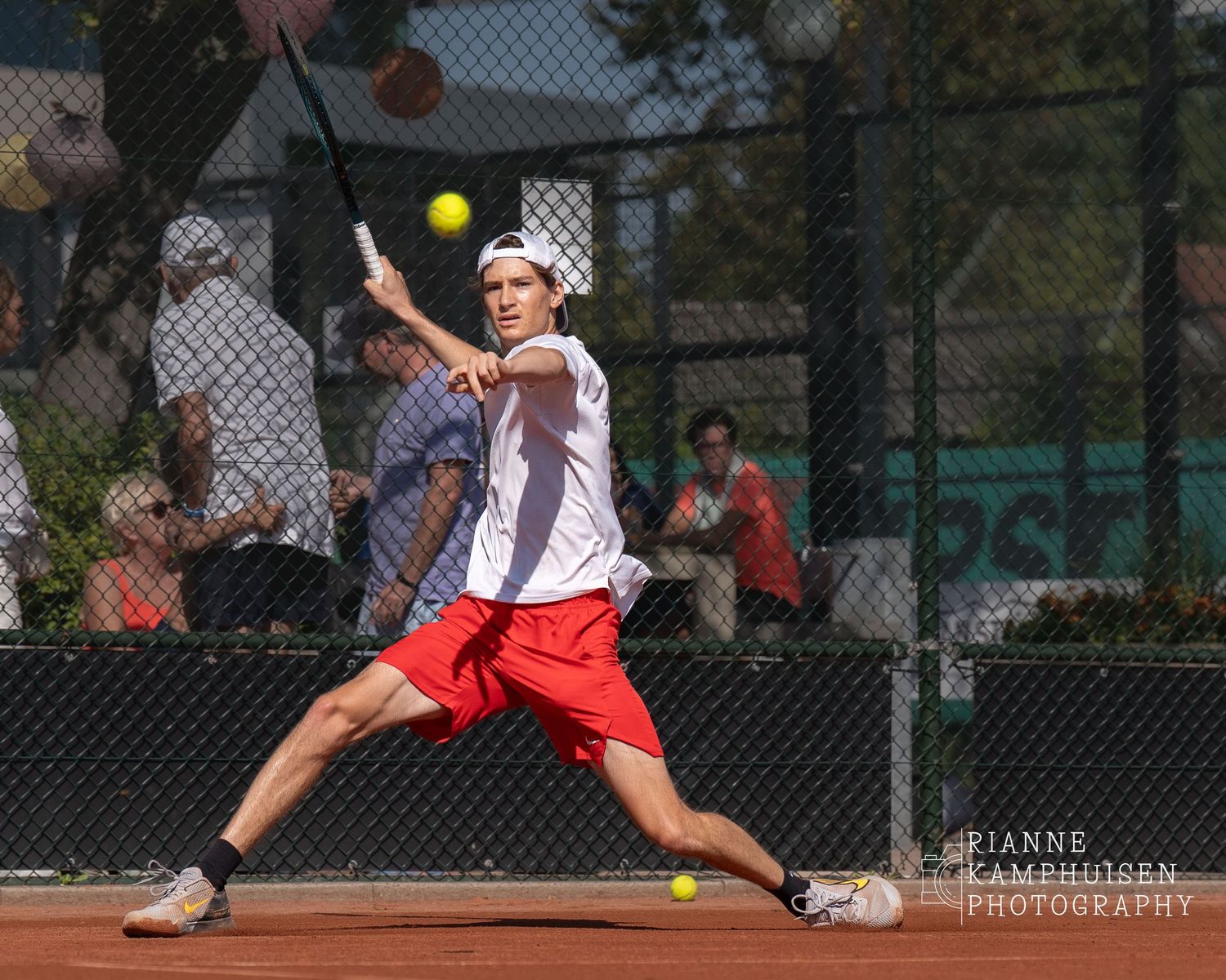Tennisspeler kijkt met volle focus naar de bal voordat hij een winnende forehand slaat