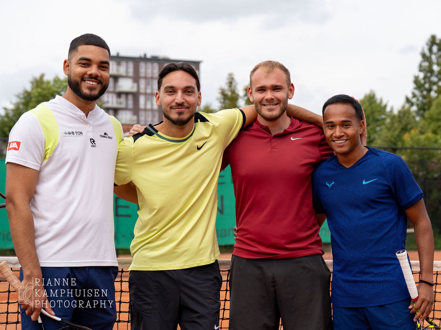 Actiefoto's en finalisten van een gravel tennistoernooi met spelers in actie, dubbelspel, toeschouwers en zomerse sfeer rond de baan.