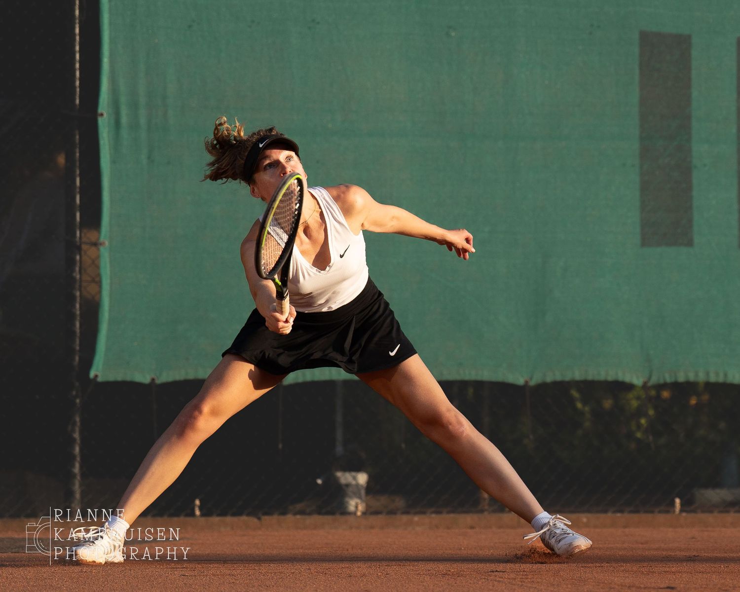 Actiefoto's van gravel tennistoernooi met spelers in actie, dubbelspel, toeschouwers en zomerse sfeer rond de baan.