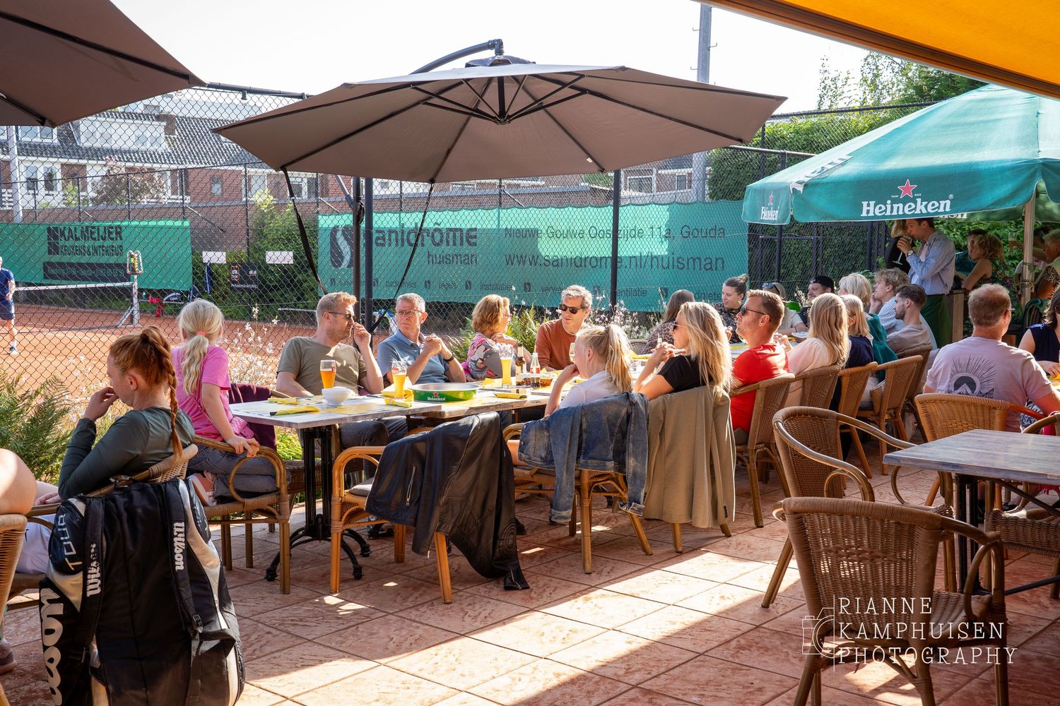 Actiefoto's van de woensdagavond van eengravel tennistoernooi met spelers in actie, dubbelspel, toeschouwers en zomerse sfeer rond de baan.
