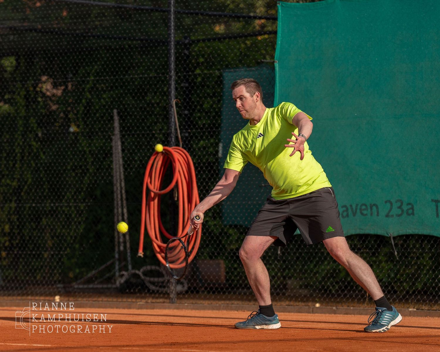 Actiefoto's van gravel tennistoernooi met spelers in actie, dubbelspel, toeschouwers en zomerse sfeer rond de baan.