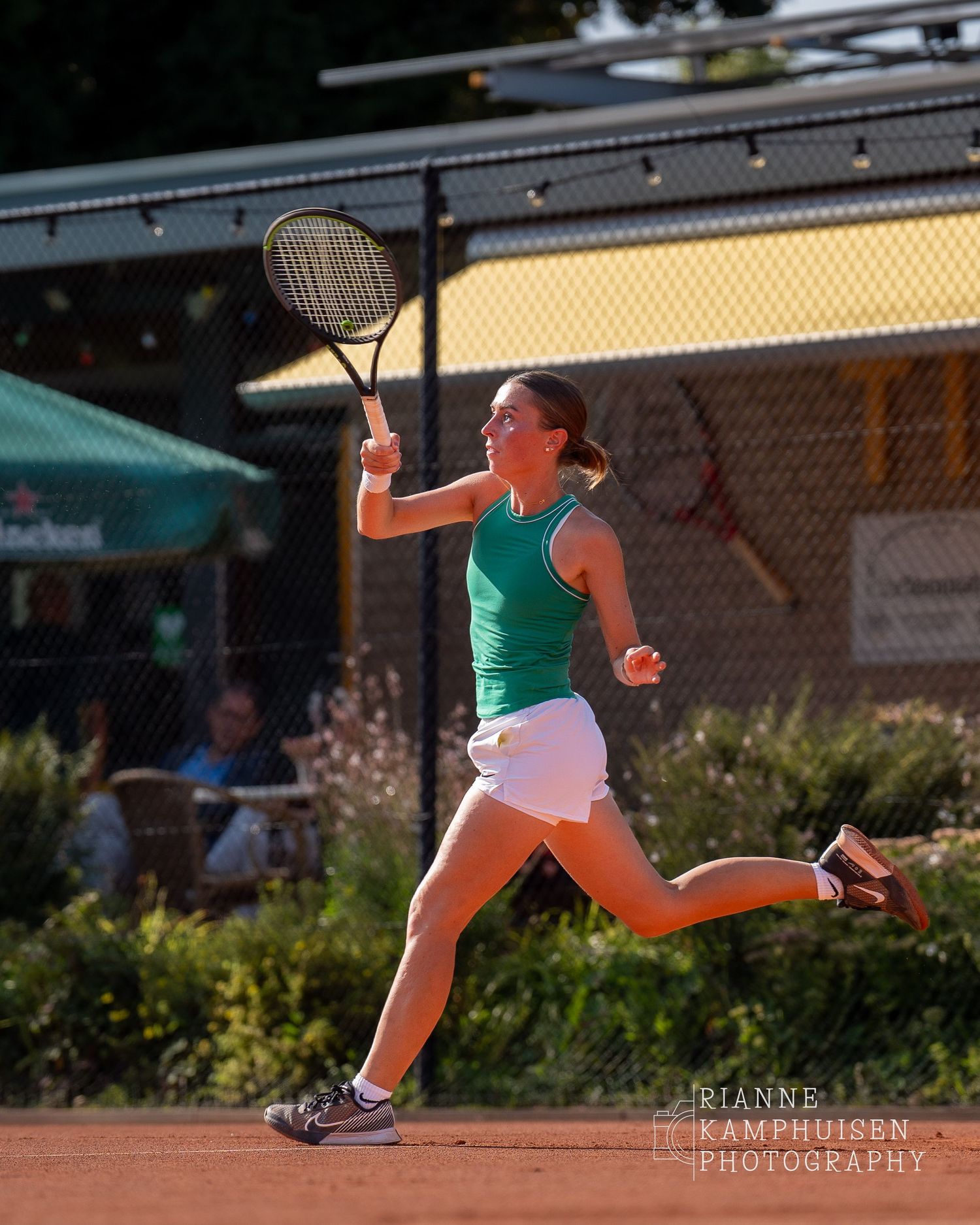 Actiefoto's van gravel tennistoernooi met spelers in actie, dubbelspel, toeschouwers en zomerse sfeer rond de baan.