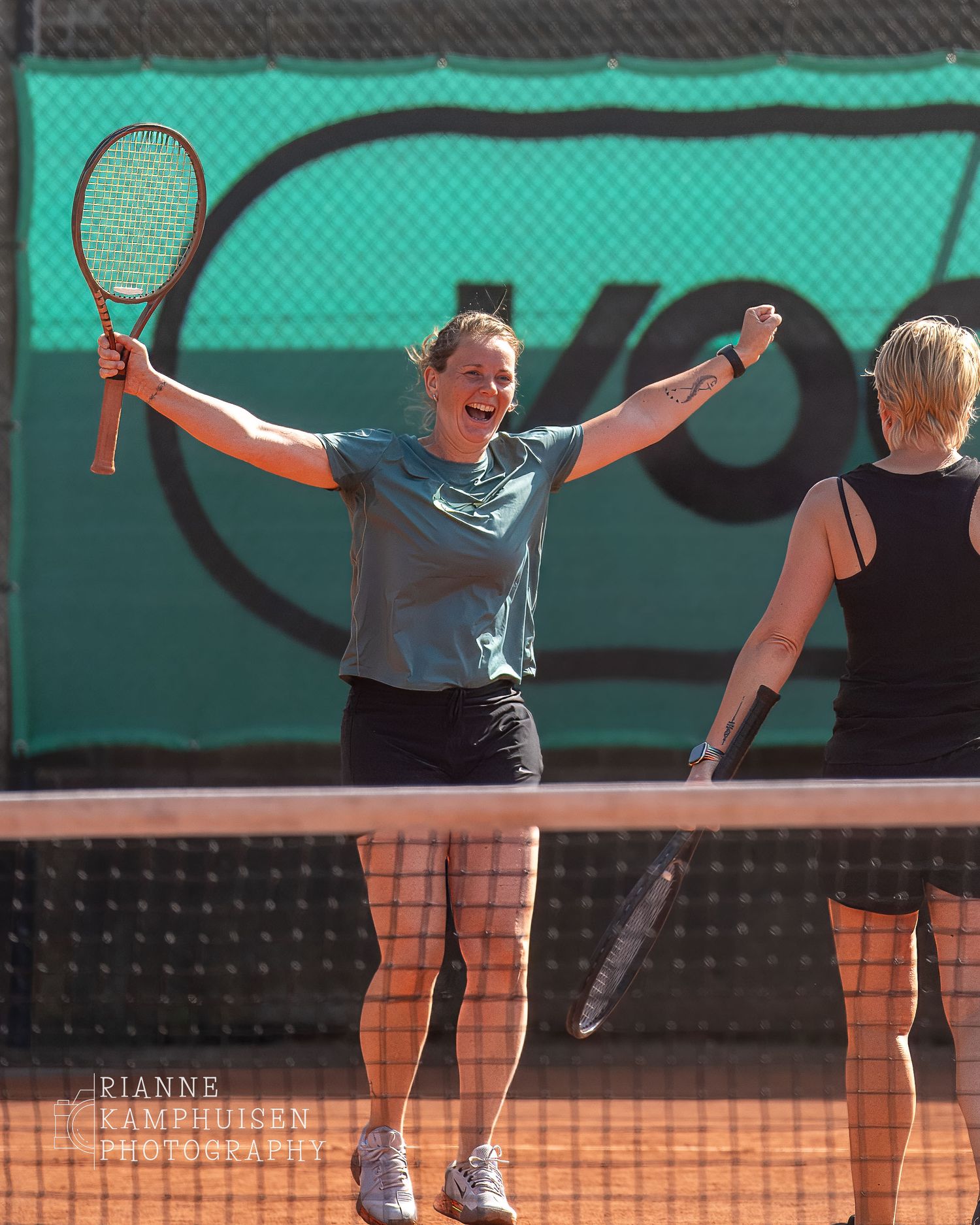 Actiefoto's en finalisten van een gravel tennistoernooi met spelers in actie, dubbelspel, toeschouwers en zomerse sfeer rond de baan.