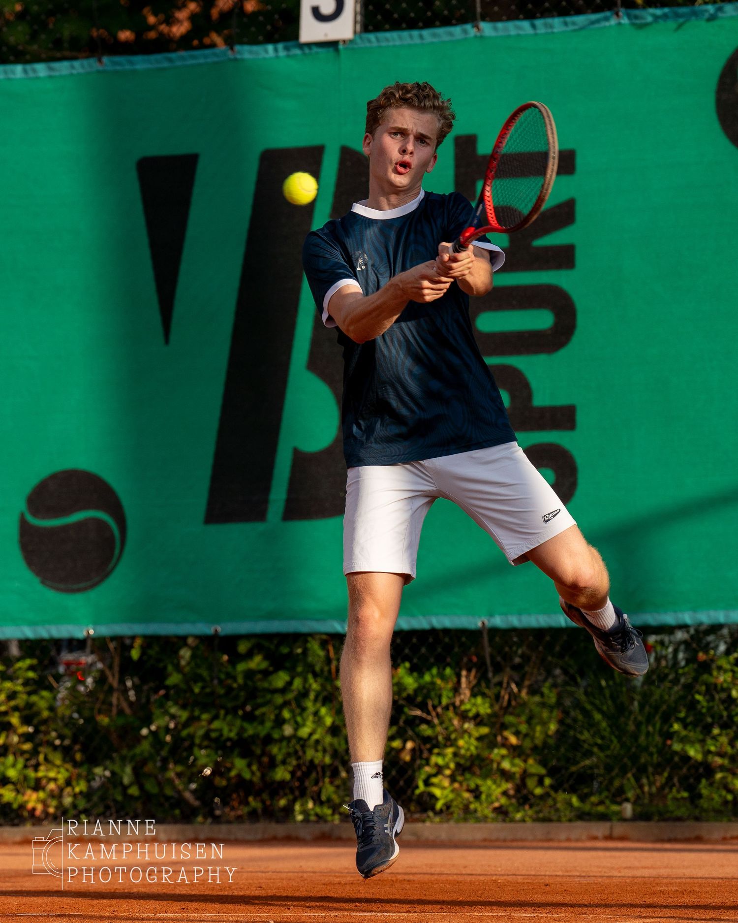 Actiefoto's van gravel tennistoernooi met spelers in actie, dubbelspel, toeschouwers en zomerse sfeer rond de baan.
